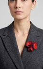 Vista frontal del broche Bouquet Bourgogne de Ciléa Paris prendido en la solapa de una chaqueta de traje gris oscura, detallando su volumen tridimensional.