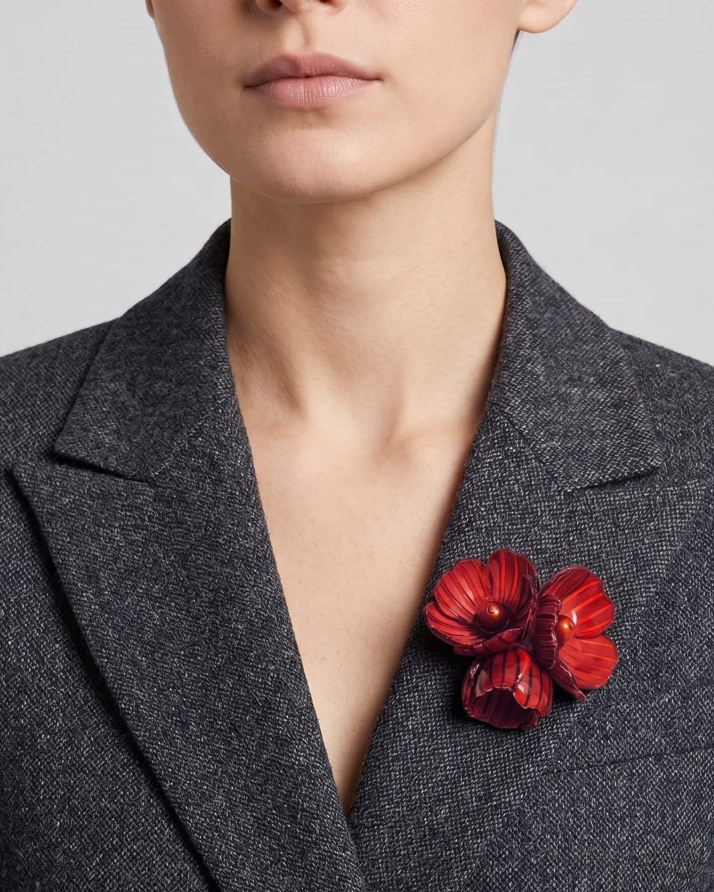 Vista frontal del broche Bouquet Bourgogne de Ciléa Paris prendido en la solapa de una chaqueta de traje gris oscura, detallando su volumen tridimensional.