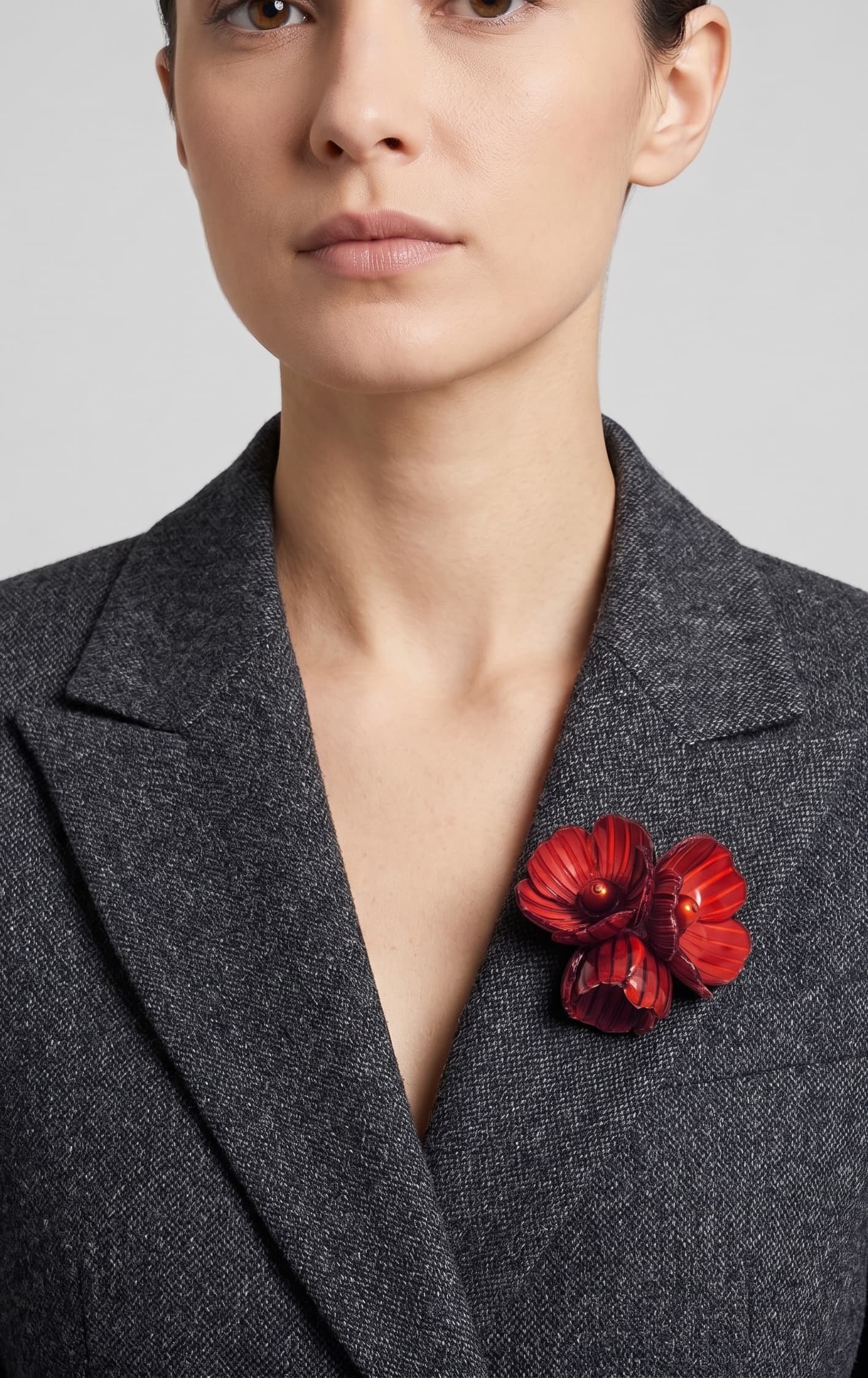 Vista frontal del broche Bouquet Bourgogne de Ciléa Paris prendido en la solapa de una chaqueta de traje gris oscura, detallando su volumen tridimensional.