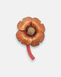 Maxibroche de diseño francés de Ciléa Paris en forma de flor exótica, mostrando sus pétalos ondulados en rojo borgoña esmaltado, centro rugoso y hojas basales.