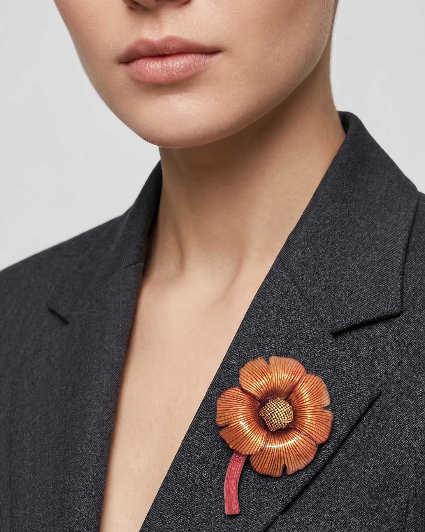 Vista frontal del gran broche floral borgoña de Ciléa Paris prendido en la solapa de una americana de traje gris, detallando su volumen y escala tridimensional.