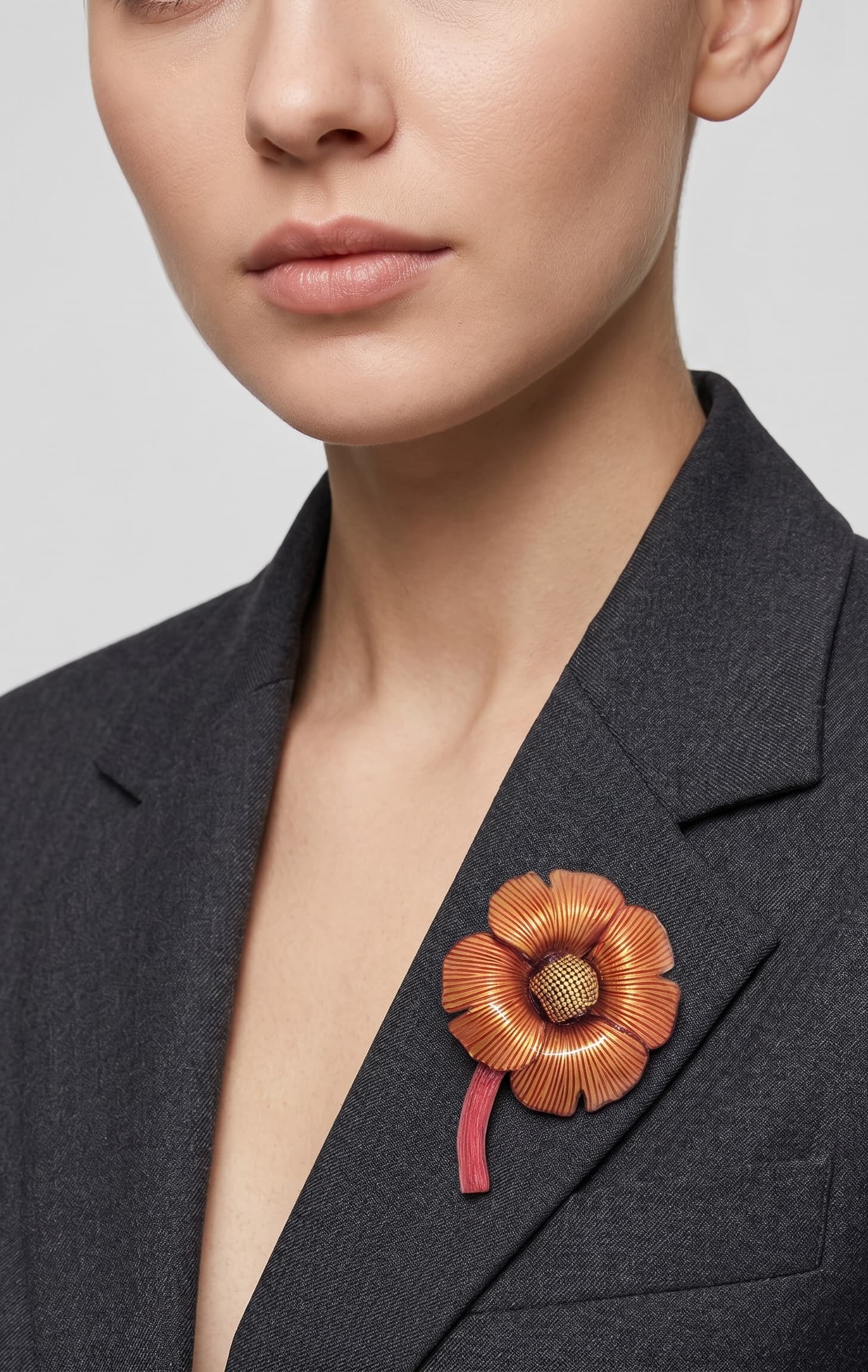 Vista frontal del gran broche floral borgoña de Ciléa Paris prendido en la solapa de una americana de traje gris, detallando su volumen y escala tridimensional.