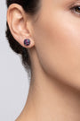 Mujer luciendo los pendientes de botón Iris Mosaic de Bohemme, resaltando su brillo vibrante y ajuste perfecto al lóbulo.