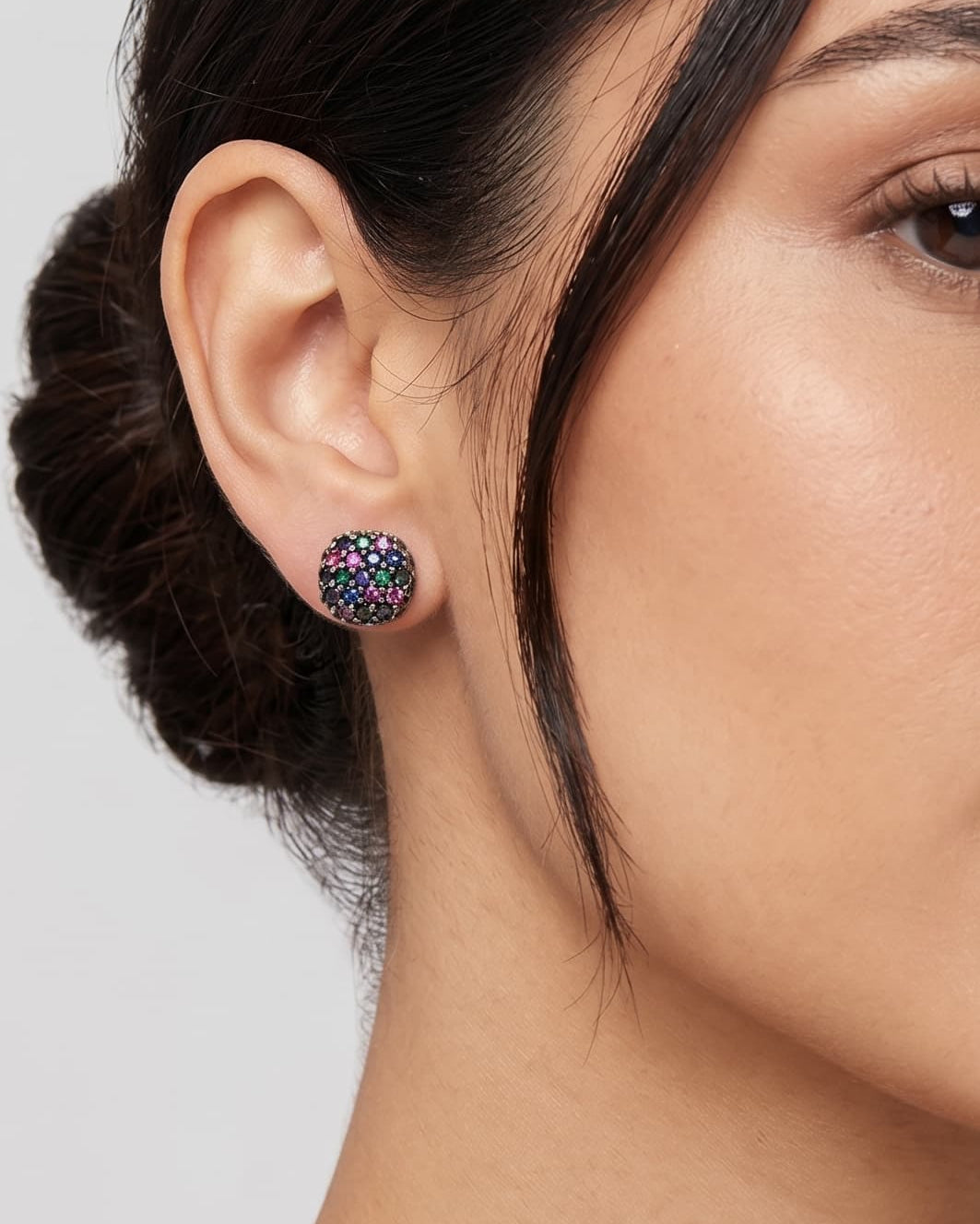 Mujer luciendo los pendientes de botón negros Obsidian Dot de Bohemme, resaltando su brillo discreto y ajuste al lóbulo.