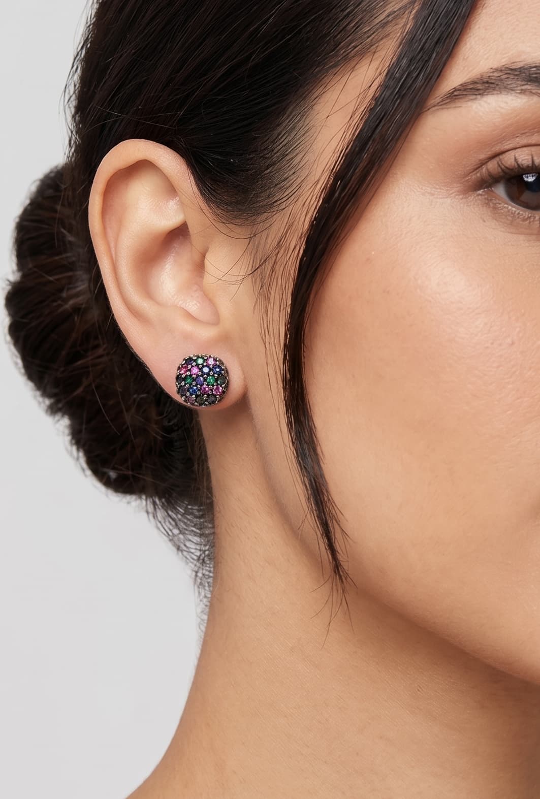 Mujer luciendo los pendientes de botón negros Obsidian Dot de Bohemme, resaltando su brillo discreto y ajuste al lóbulo.