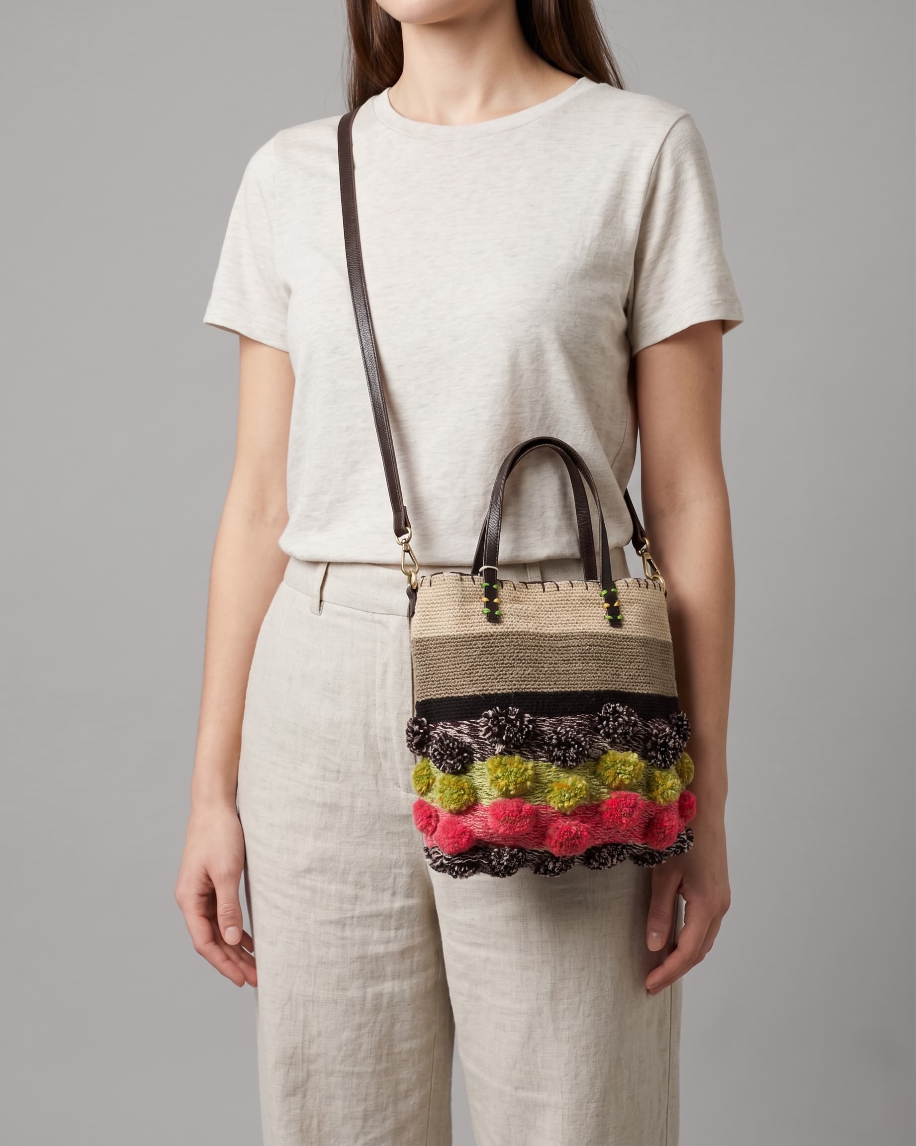 Mujer luciendo el bolso XS "Jardín de Invierno" como bandolera, destacando su tamaño compacto y diseño colorido.