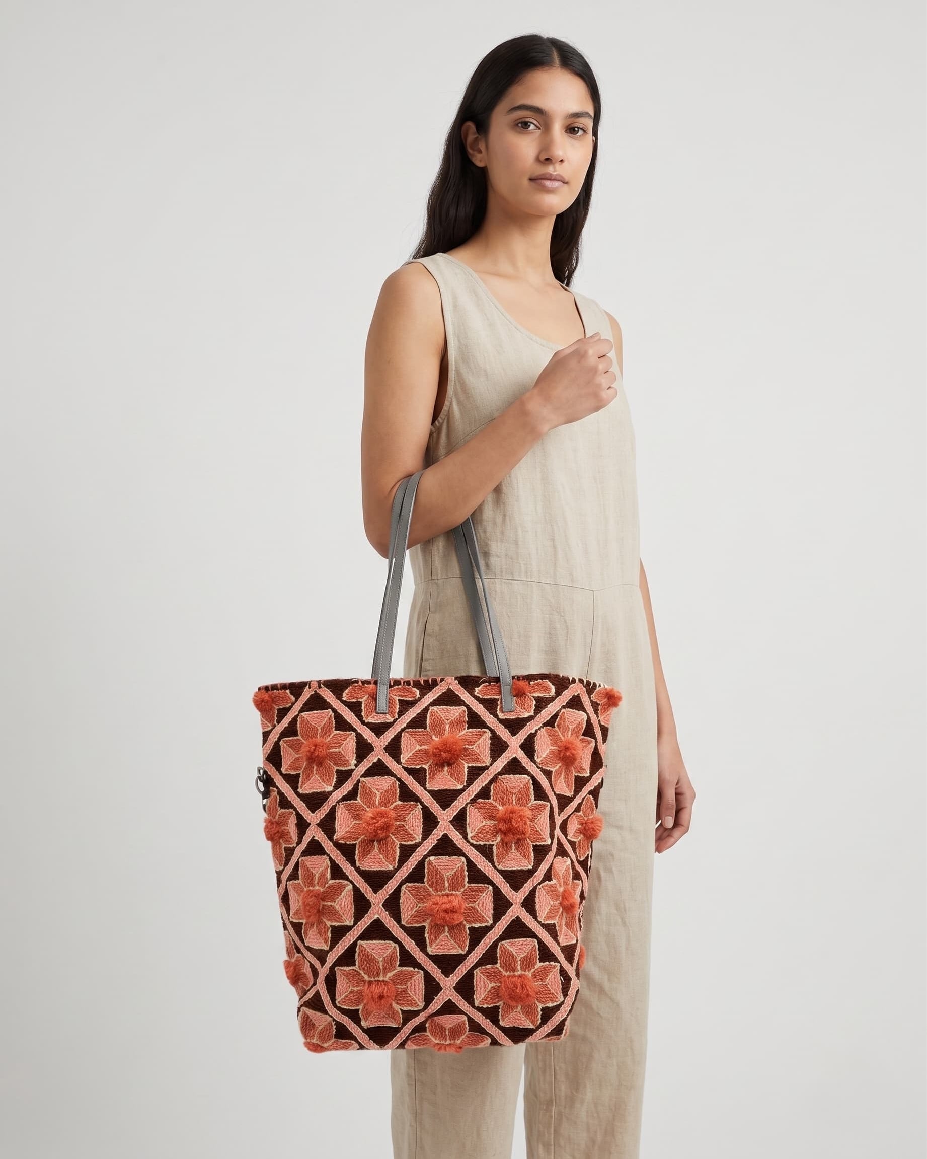 Mujer luciendo el bolso "Travesía Floral" al hombro, destacando su colorido diseño étnico y tamaño funcional.