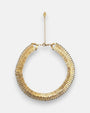 Collar gargantilla rígida Tataborello de diseño radial plisado en color oro con borde de cuentas oscuras y cadena alargadora con medalla de la marca.