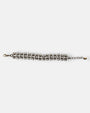 Pulsera Tataborello extendida con triple hilera de perlas y estructura de bronce antiguo.