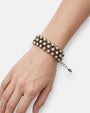 Mujer luciendo la pulsera "Constelación de Perlas" en la muñeca, resaltando su elegancia y diseño clásico.