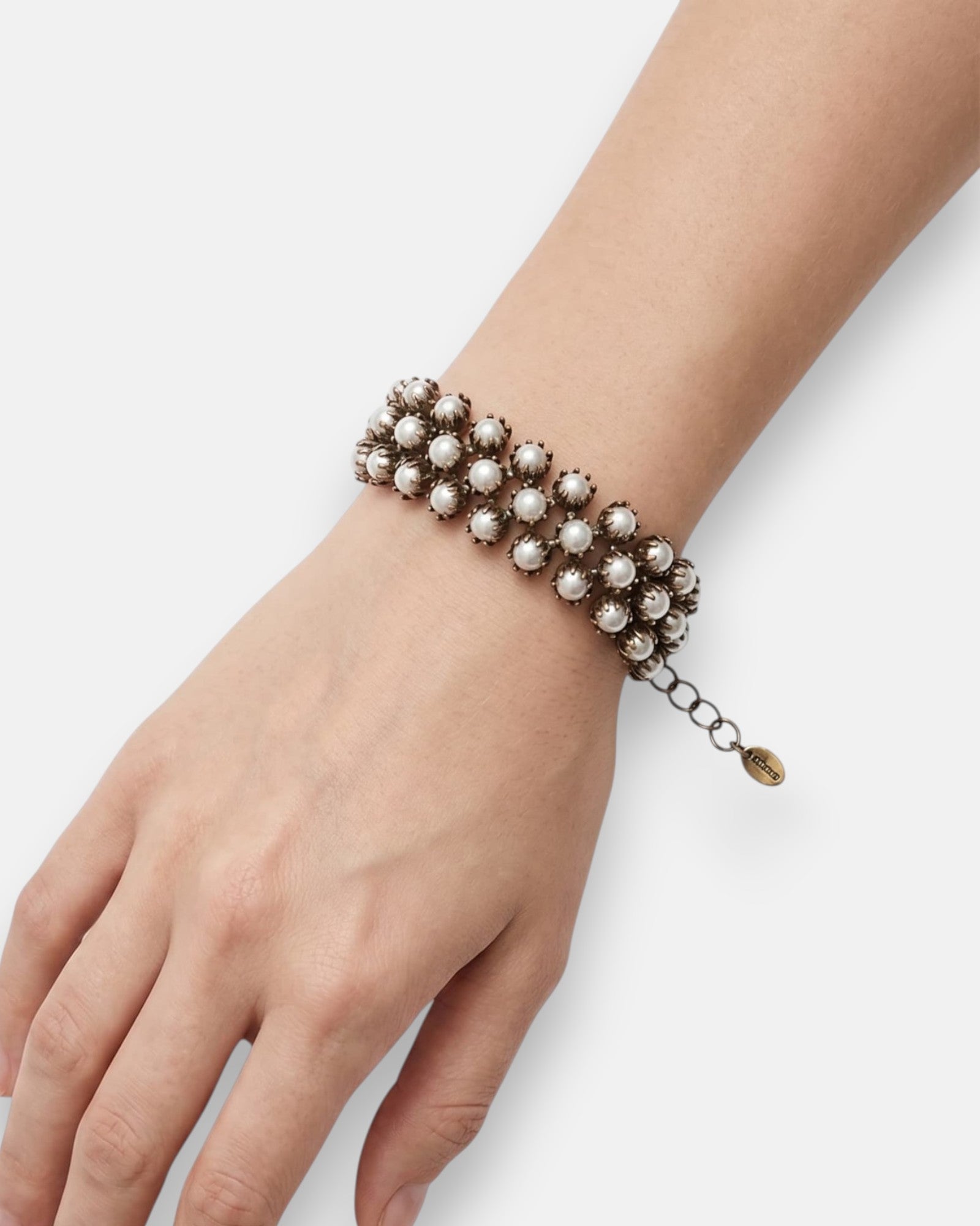 Mujer luciendo la pulsera "Constelación de Perlas" en la muñeca, resaltando su elegancia y diseño clásico.