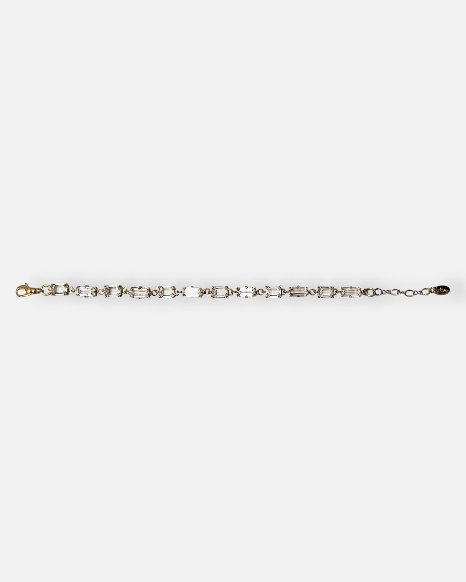 Pulsera Tataborello extendida con hilera de cristales rectangulares talla baguette y eslabones dorados.