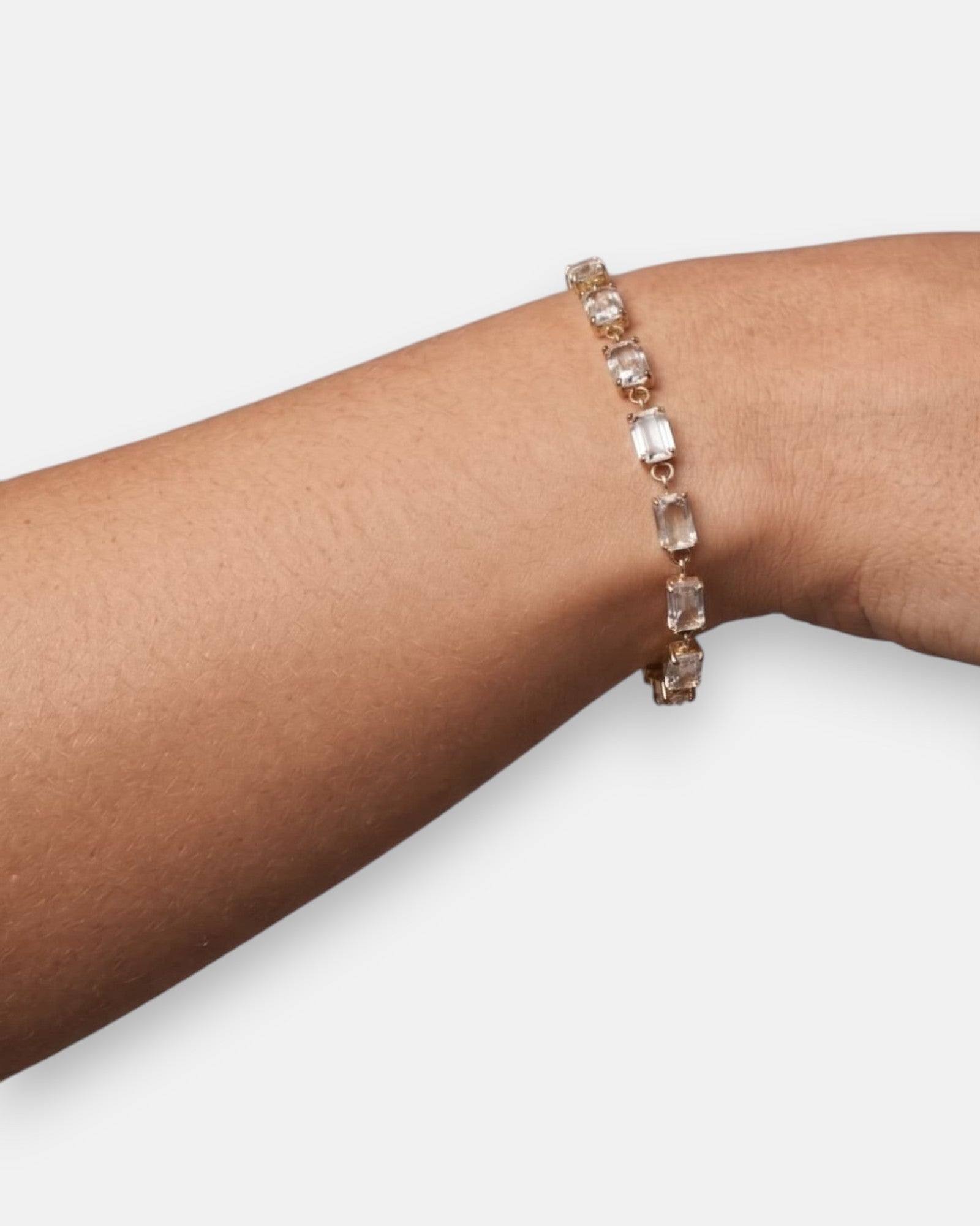 Mujer luciendo la pulsera "Rivière Baguette" en la muñeca, destacando su diseño fino y luminoso.