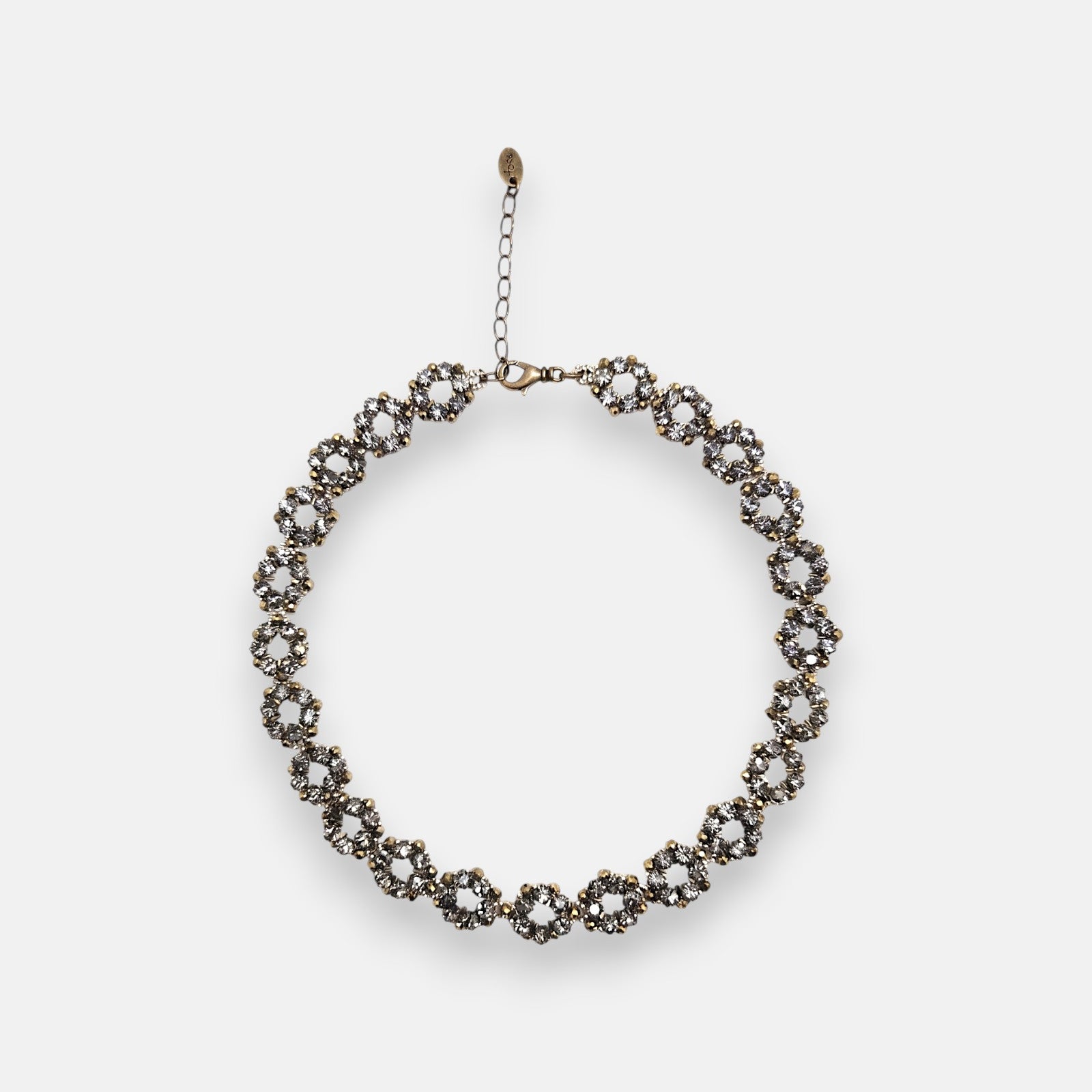 Collar gargantilla Tataborello extendido en círculo mostrando su patrón articulado de eslabones redondos calados con cristales grises y cierre ajustable.