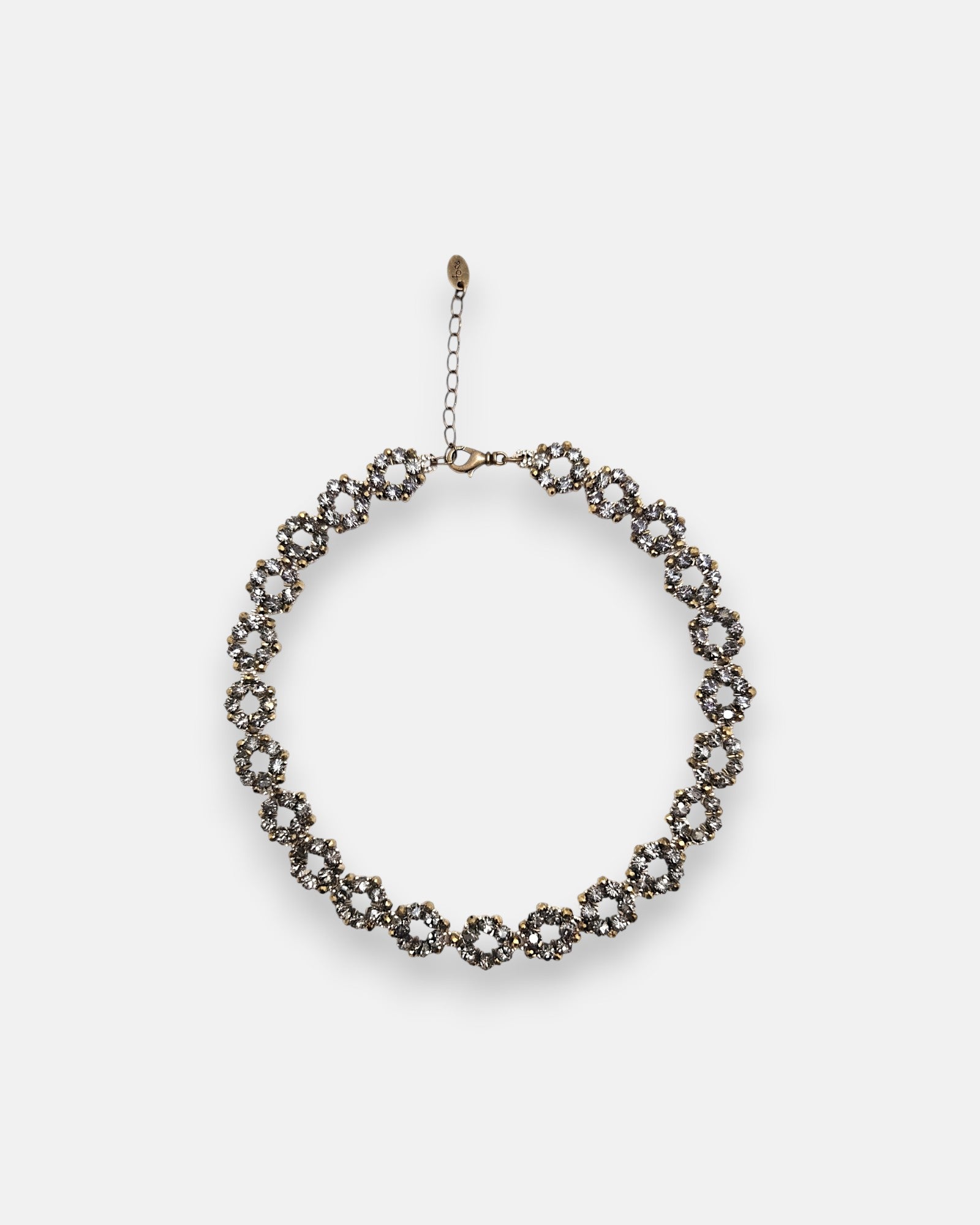 Collar gargantilla Tataborello extendido en círculo mostrando su patrón articulado de eslabones redondos calados con cristales grises y cierre ajustable.