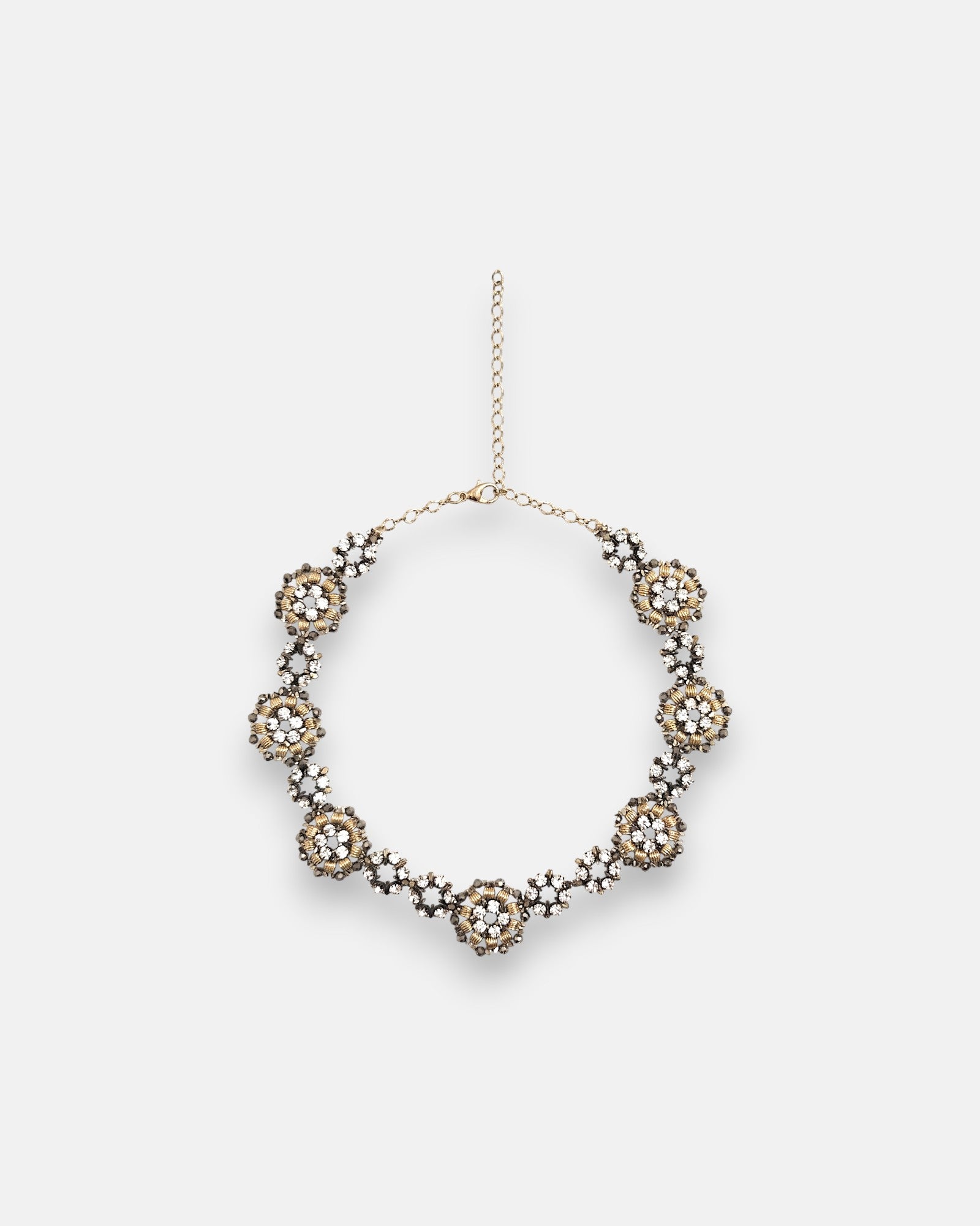 Collar gargantilla de flores Tataborello extendido en círculo mostrando su hilera continua de rosetones dorados con cristales y cadena de ajuste.