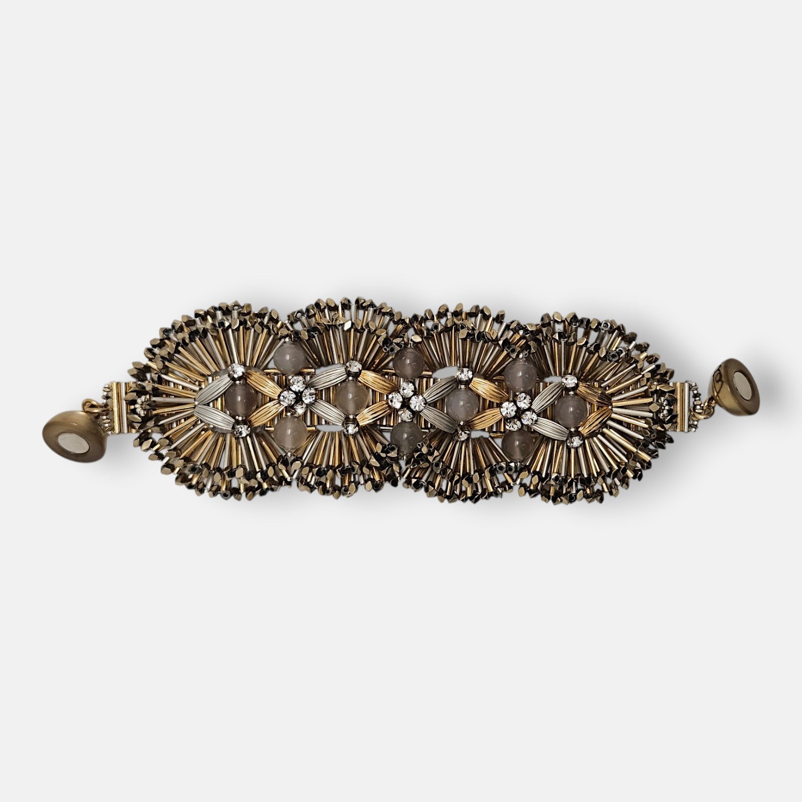 Maxi pulsera ancha Tataborello extendida con eslabones radiales dorados, piedras de ágata gris y cierre magnético.