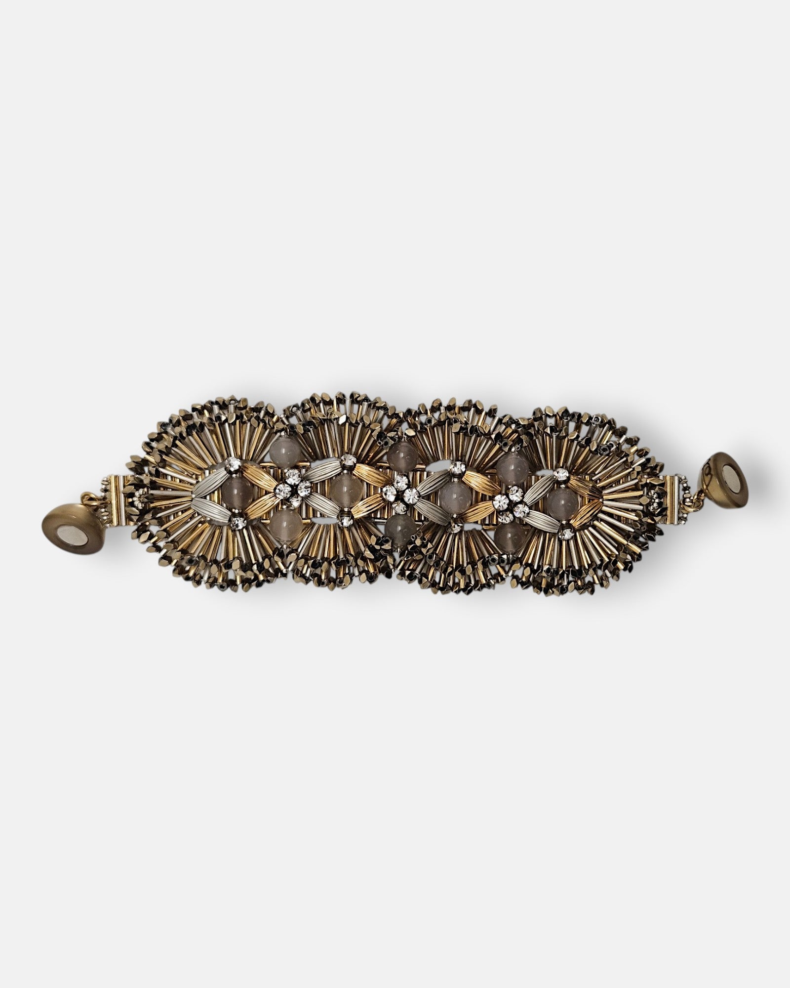 Maxi pulsera ancha Tataborello extendida con eslabones radiales dorados, piedras de ágata gris y cierre magnético.