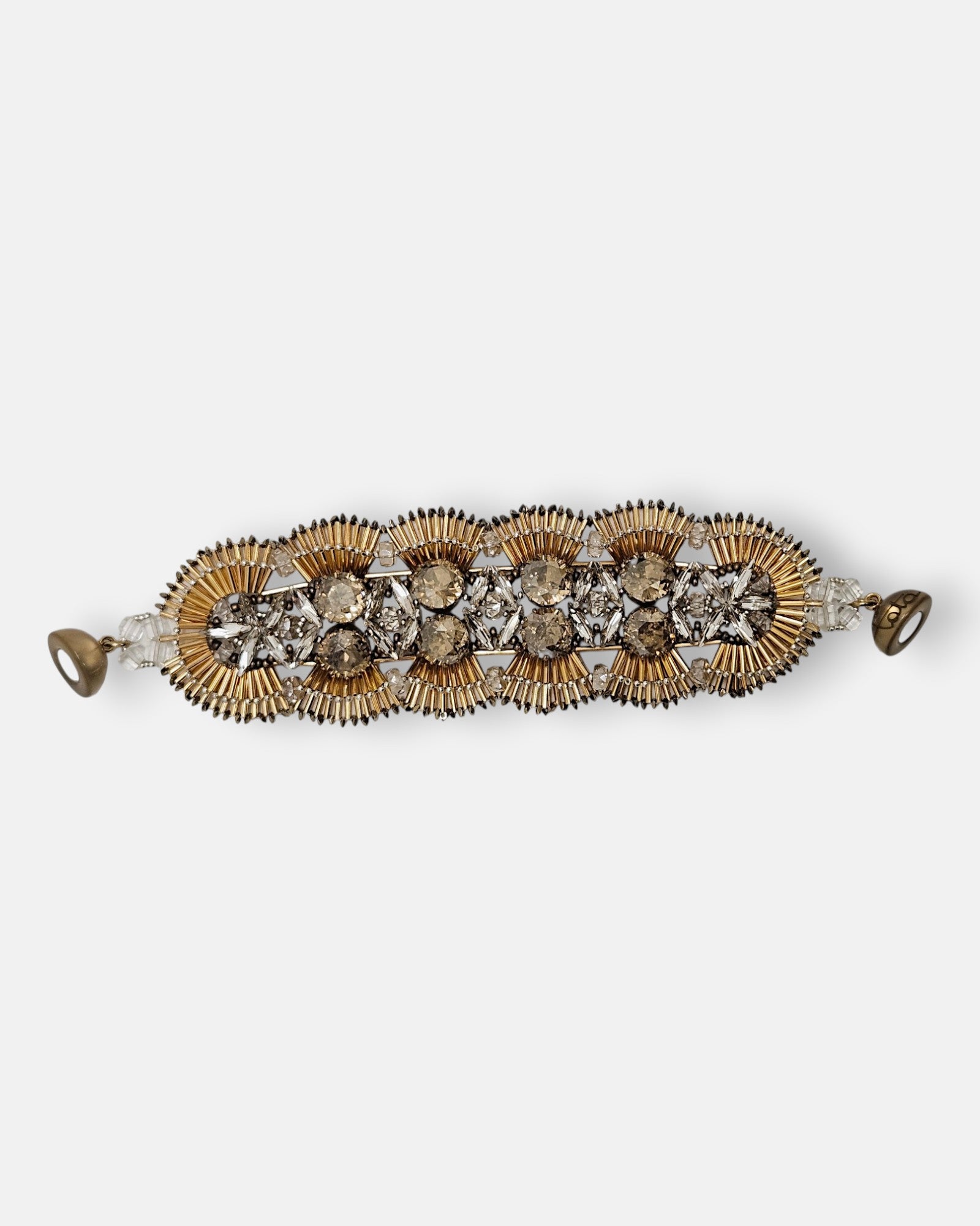 Maxi pulsera ancha Tataborello extendida con eslabones en forma de abanicos dorados, cristales y cierre magnético.