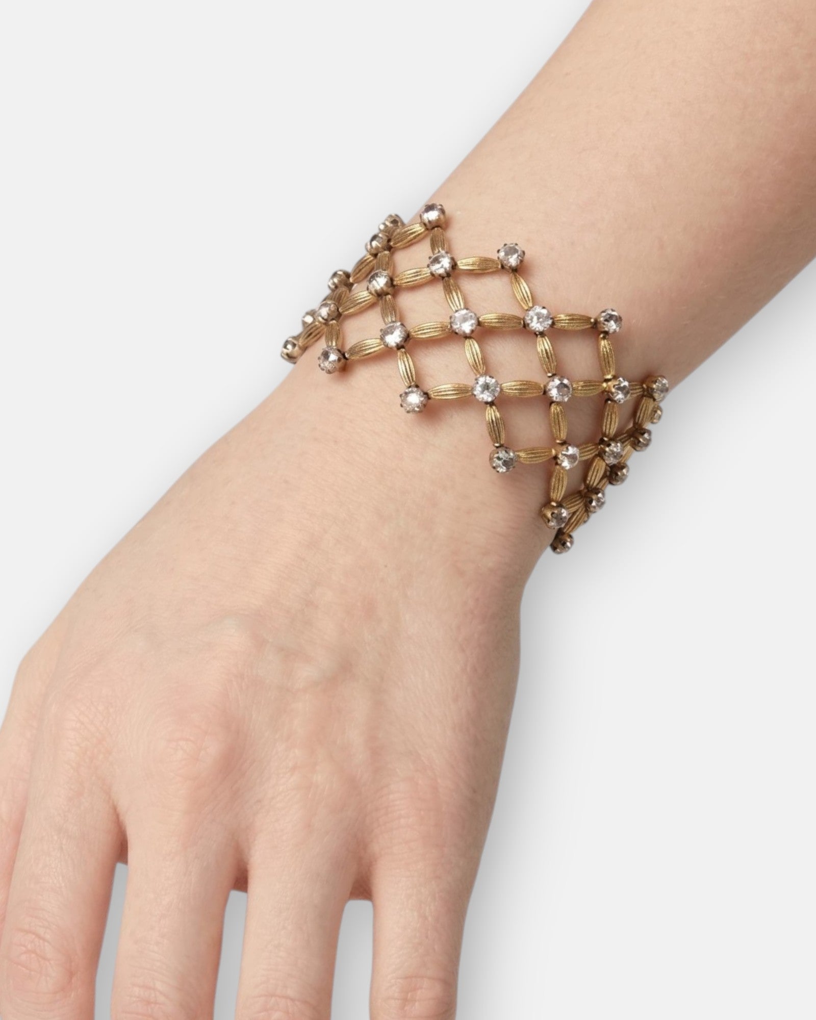 Vista del brazalete de rejilla "Red de Luces" en la muñeca, mostrando su transparencia calada y formato ancho.