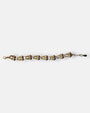 Pulsera fina Tataborello extendida con parejas de eslabones dorados en forma de gota y cristales brillantes.