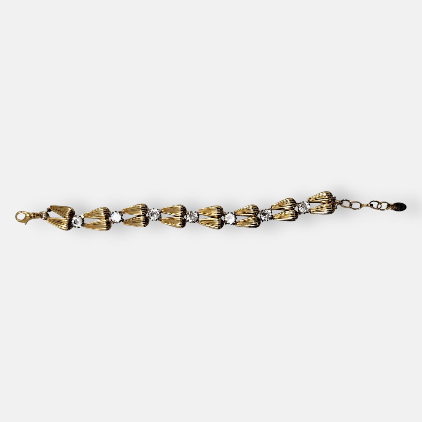Pulsera fina Tataborello extendida con parejas de eslabones dorados en forma de gota y cristales brillantes.
