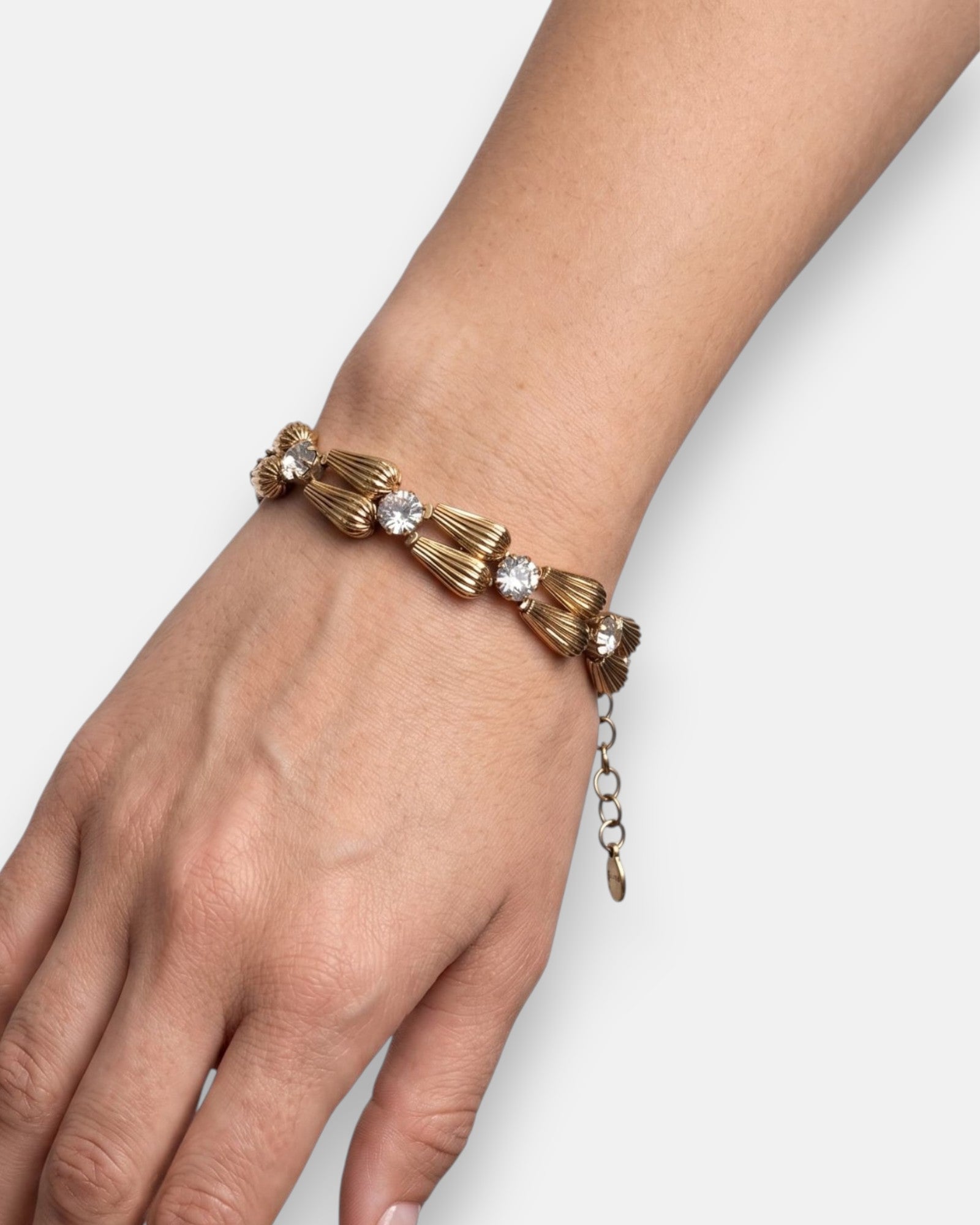 Vista de la pulsera "Gota de Luz" colocada en la muñeca, resaltando su brillo dorado y su diseño fino.