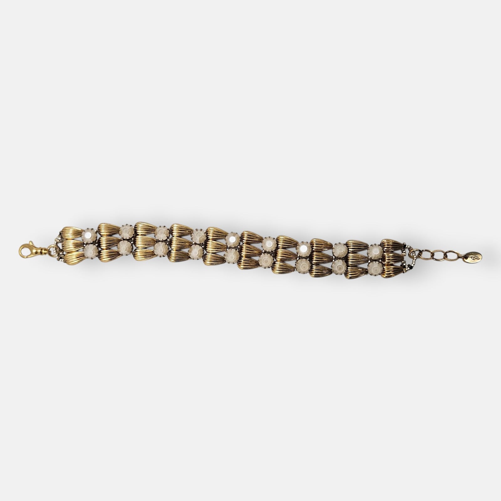 Pulsera ancha Tataborello extendida con doble hilera de eslabones dorados en gota y cristales ópalo.