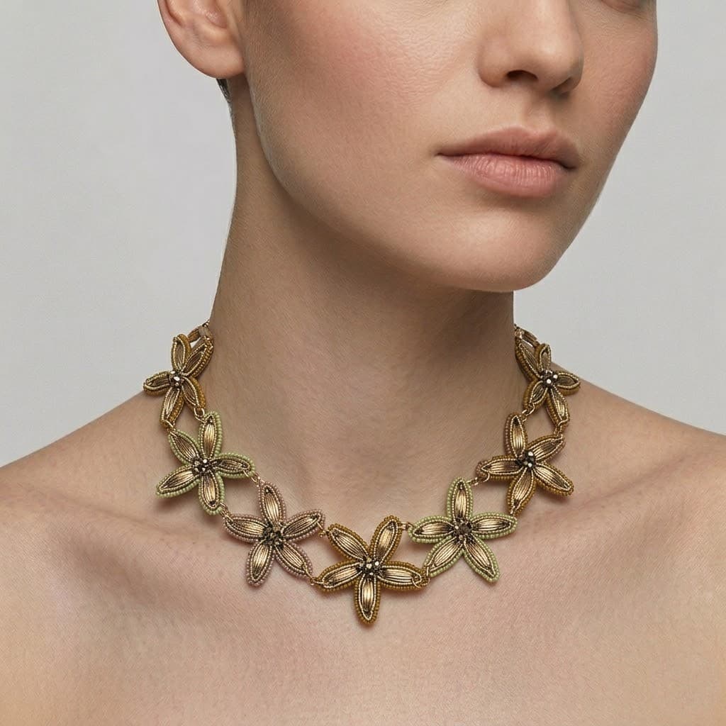 Vista frontal de una modelo portando el collar pechera de diseño orgánico Gala Botánica Máxi de Tataborello, destacando su gran volumen dorado sobre el escote.