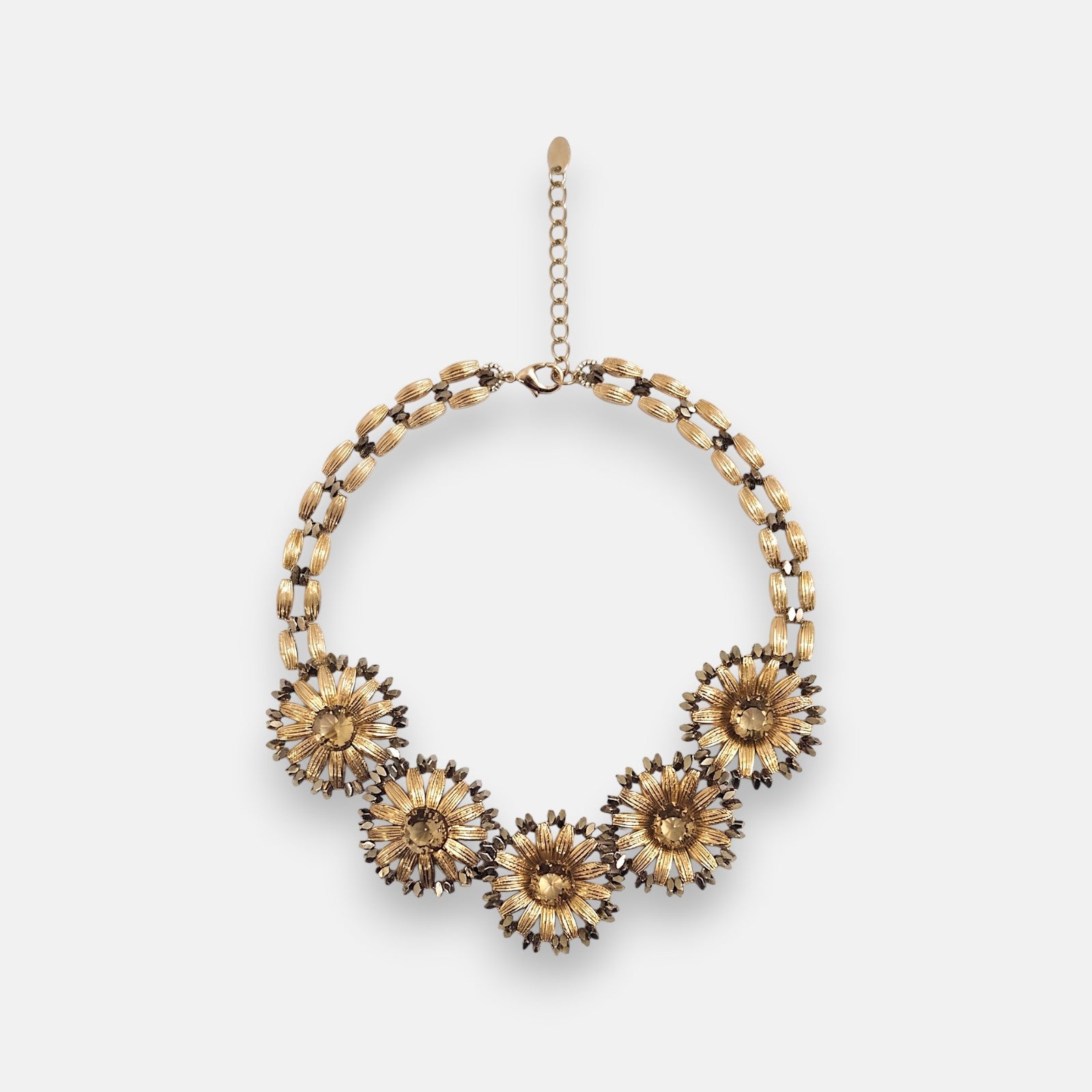Collar pechera de Tataborello de 47 cm extendido en círculo mostrando su frontal de hojas doradas colgantes, cuentas grises y cordón de hilos finos.