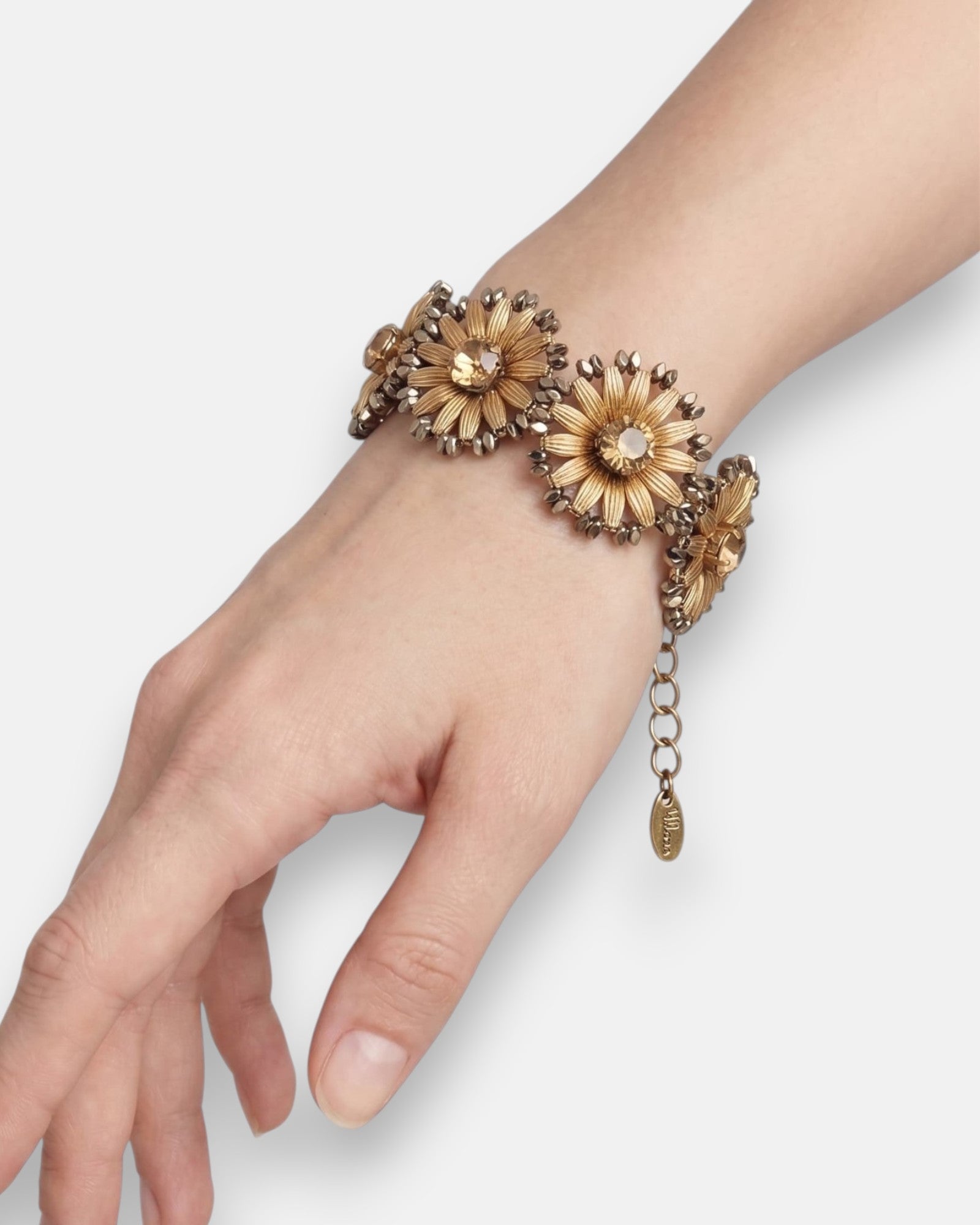 Vista de la pulsera "Girasol de Bronce" colocada en la muñeca, destacando su anchura y su relieve floral tridimensional.
