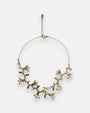 Collar gargantilla asimétrica de Tataborello extendido en círculo mostrando su estructura de rama botánica bordada en bronce con flores doradas.
