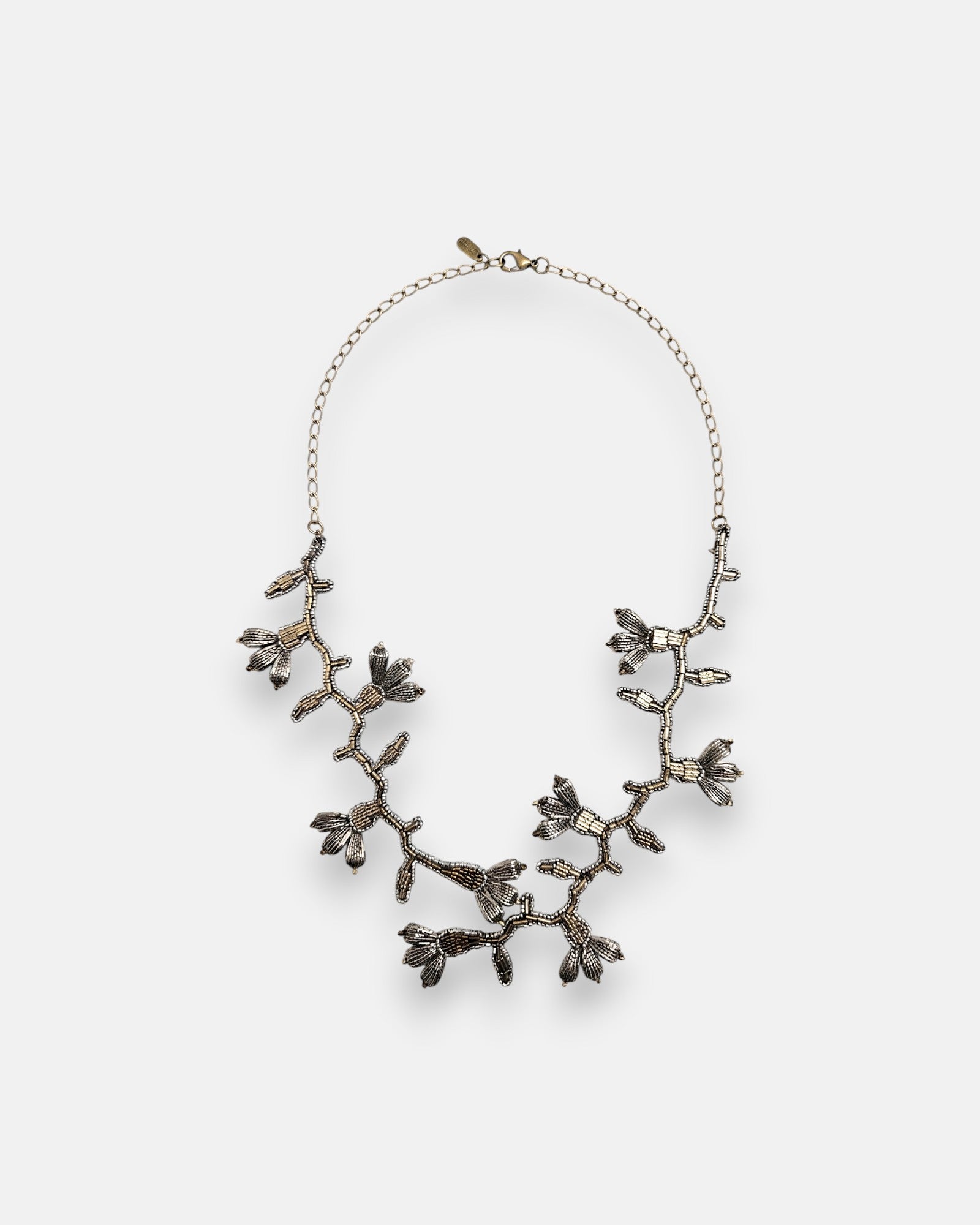 Collar pechera largo Tataborello extendido en círculo mostrando su compleja estructura de enredadera botánica tejida con cuentas de plata vieja y oro.