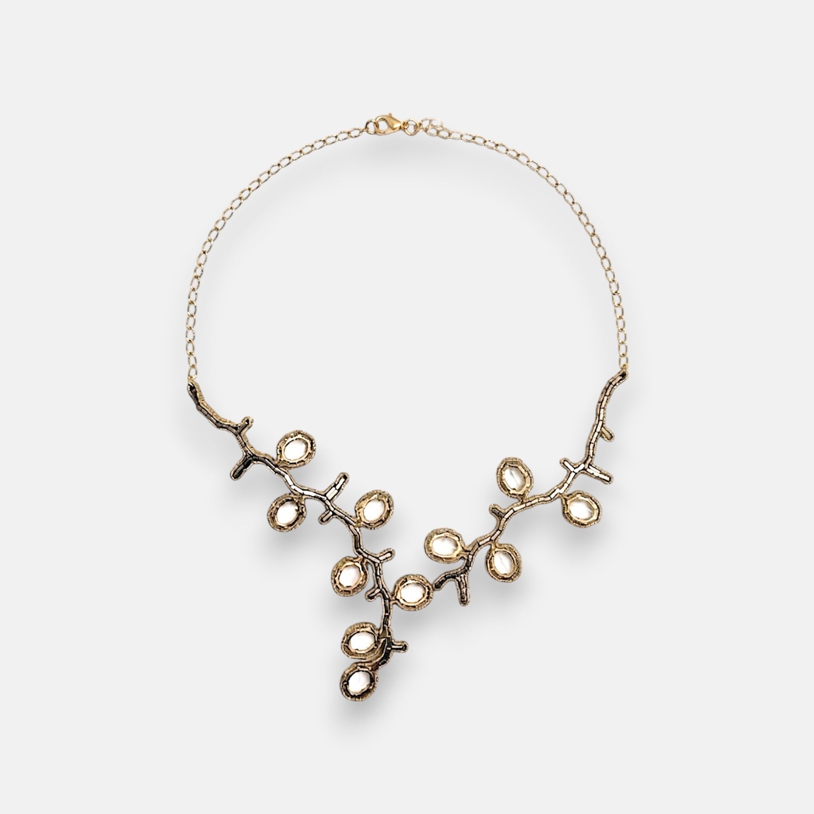 Collar pechera de gran formato Tataborello de 53 cm extendido en círculo mostrando su frontal articulado de rosetones calados con cristales negros y bronce.