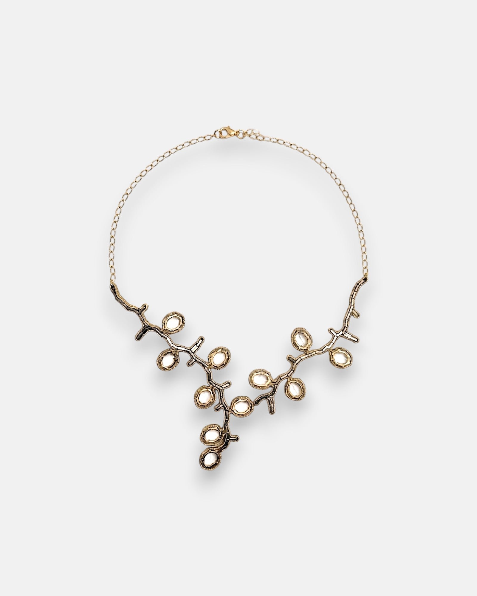 Collar pechera de gran formato Tataborello de 53 cm extendido en círculo mostrando su frontal articulado de rosetones calados con cristales negros y bronce.