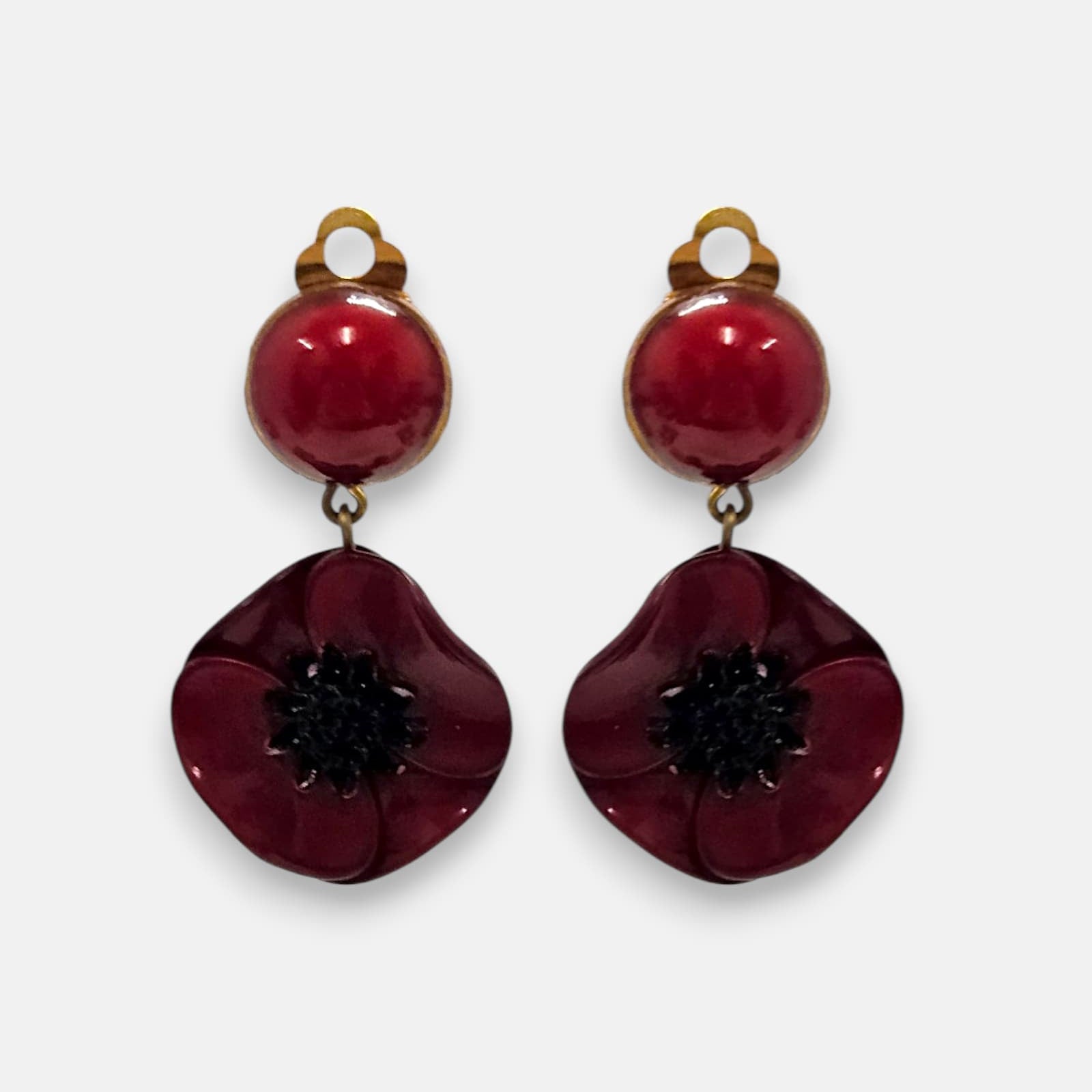 Pareja de pendientes de amapola de Ciléa Paris con pétalos en color rojo borgoña brillante, centro negro texturizado y botón superior esférico a juego.
