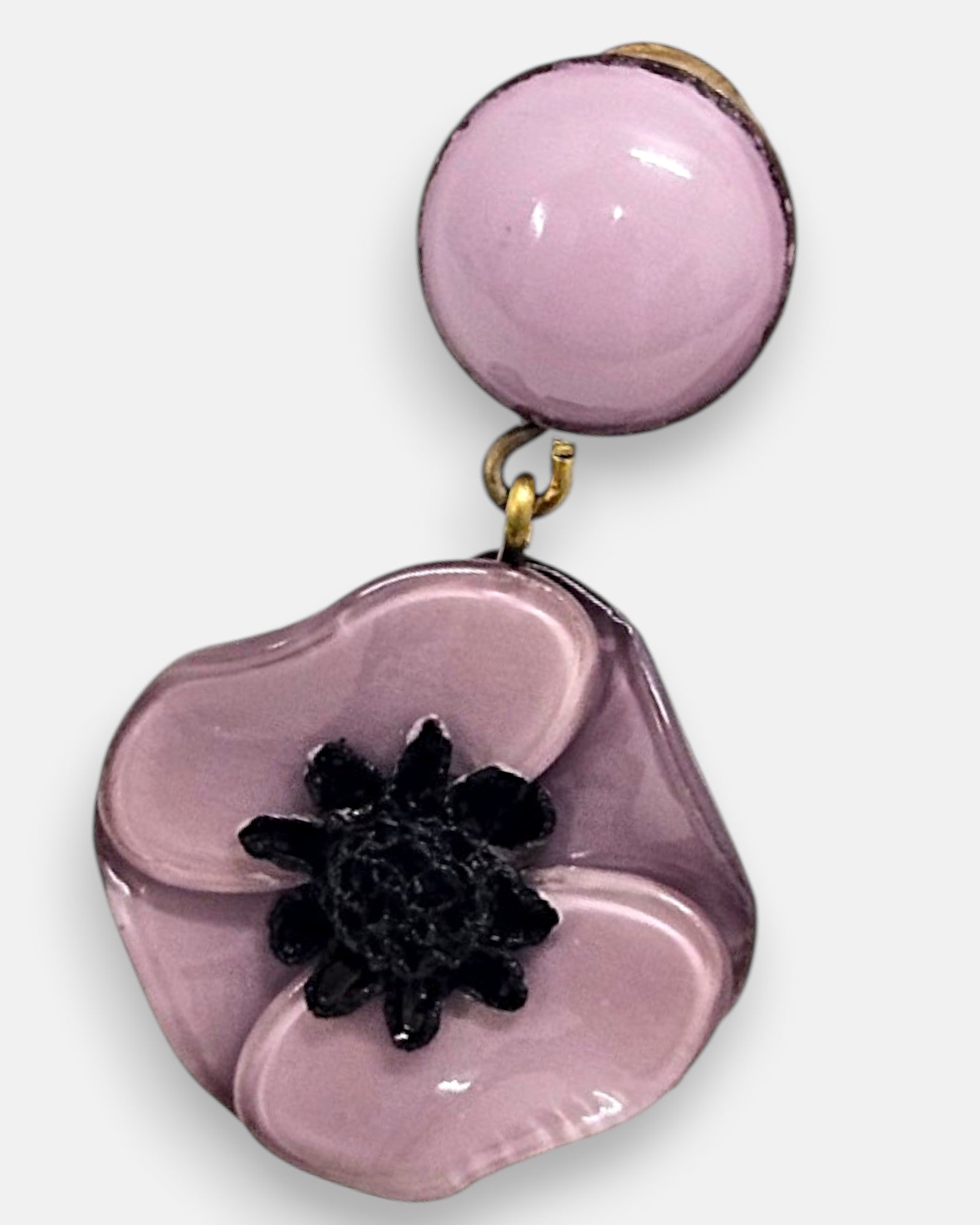 Primer plano macro de un pendiente artesanal de Ciléa Paris, detallando el juego de reflejos satinados sobre los pétalos rosa malva modelados y el acabado del botón superior.