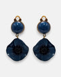 Pareja de pendientes de amapola de Ciléa Paris con pétalos en color azul petróleo esmaltado, centro negro texturizado y botón superior con enganche de pinza.