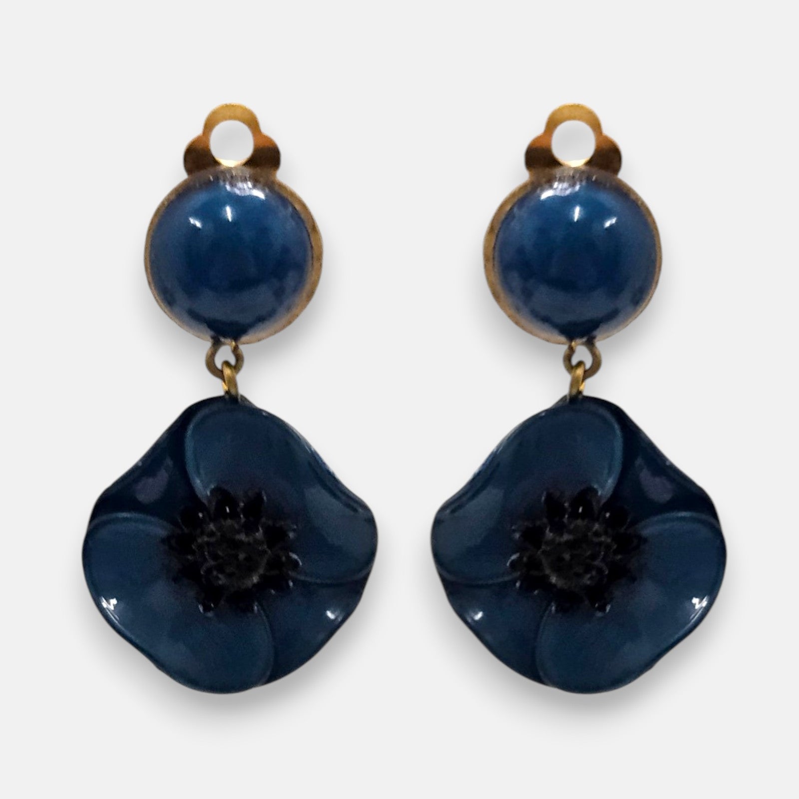 Pareja de pendientes de amapola de Ciléa Paris con pétalos en color azul petróleo esmaltado, centro negro texturizado y botón superior con enganche de pinza.