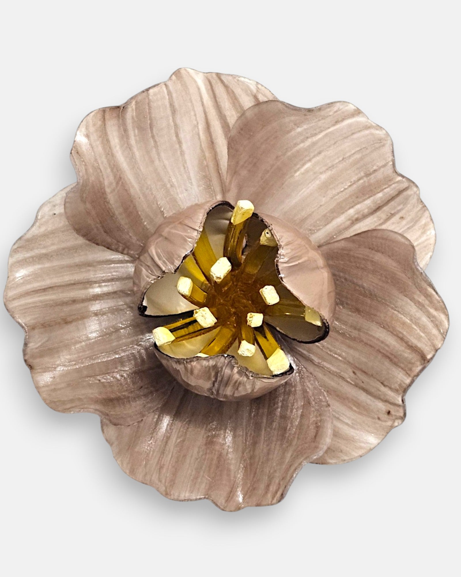 primer plano del broche artesanal de Ciléa Paris, enfocando los reflejos nacarados de los pétalos modelados y la profundidad translúcida de su centro dorado.