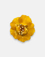 broche en forma de flor abierta de Ciléa Paris con pétalos estriados en color amarillo brillante, un cáliz central elevado y pistilos texturizados.