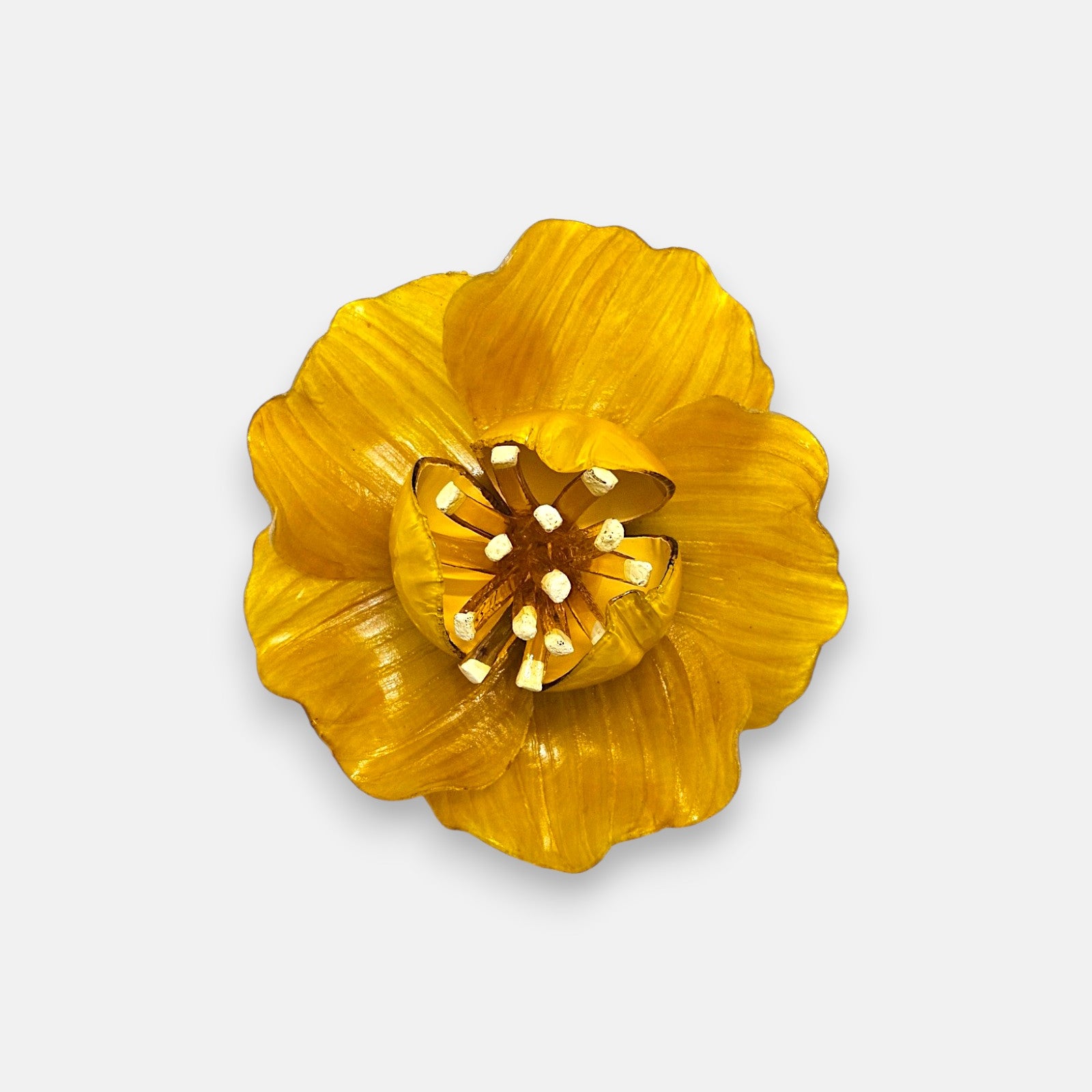 broche en forma de flor abierta de Ciléa Paris con pétalos estriados en color amarillo brillante, un cáliz central elevado y pistilos texturizados.
