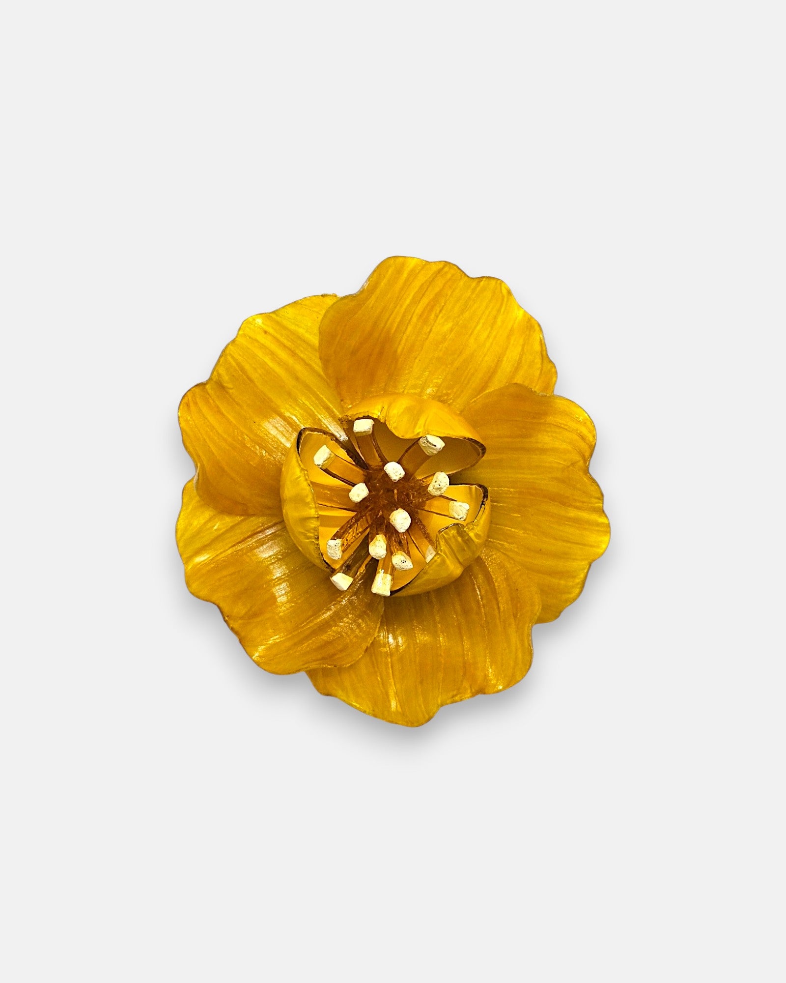 broche en forma de flor abierta de Ciléa Paris con pétalos estriados en color amarillo brillante, un cáliz central elevado y pistilos texturizados.