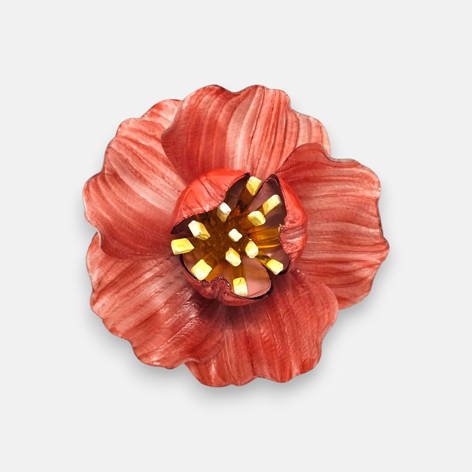 broche en forma de flor abierta de Ciléa Paris con pétalos estriados en color rojo coral, un cáliz central elevado y pistilos texturizados.