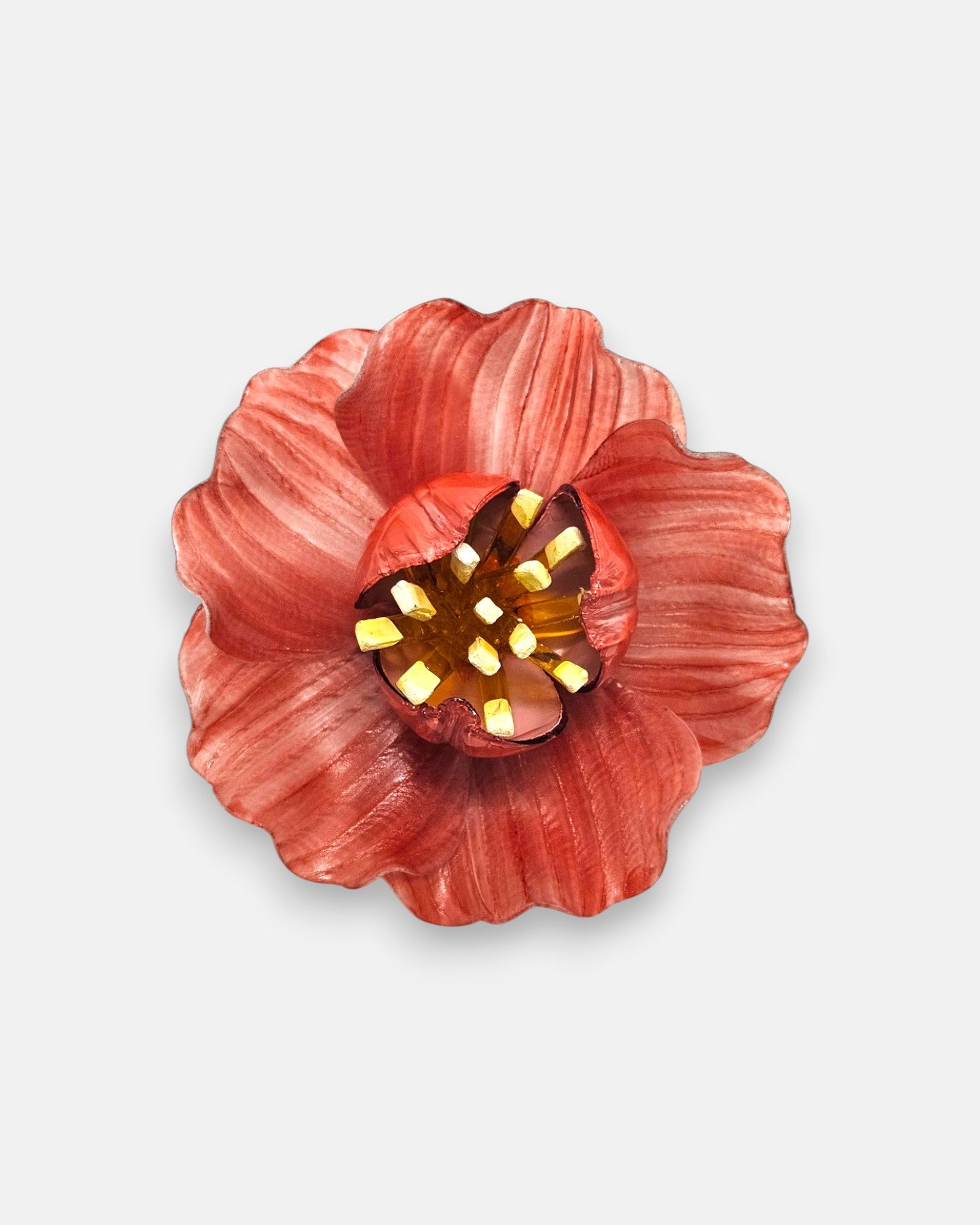 broche en forma de flor abierta de Ciléa Paris con pétalos estriados en color rojo coral, un cáliz central elevado y pistilos texturizados.
