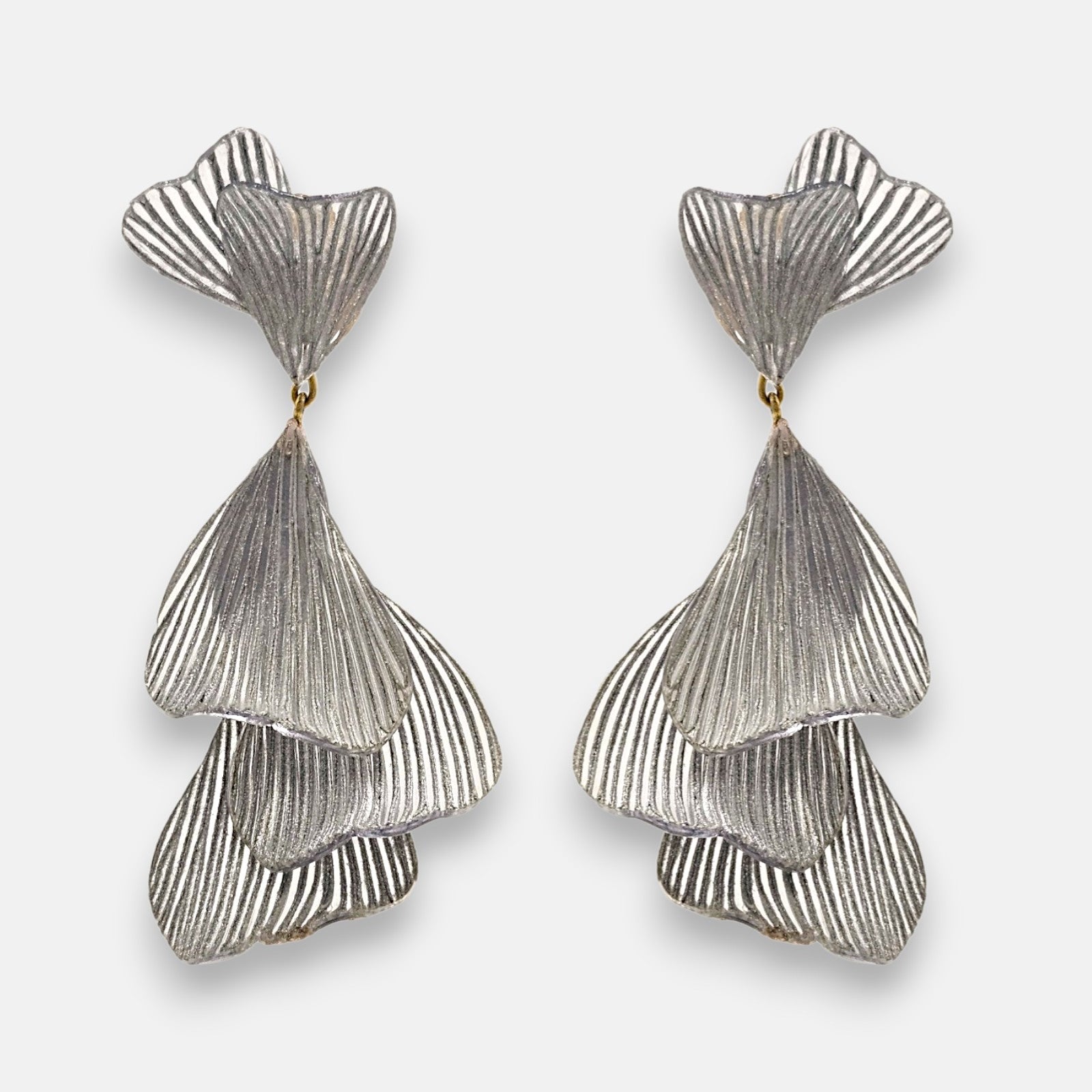 pareja de pendientes colgantes maxi de Ciléa Paris con hojas estriadas superpuestas en color plata satinada y botón superior en forma de abanico.