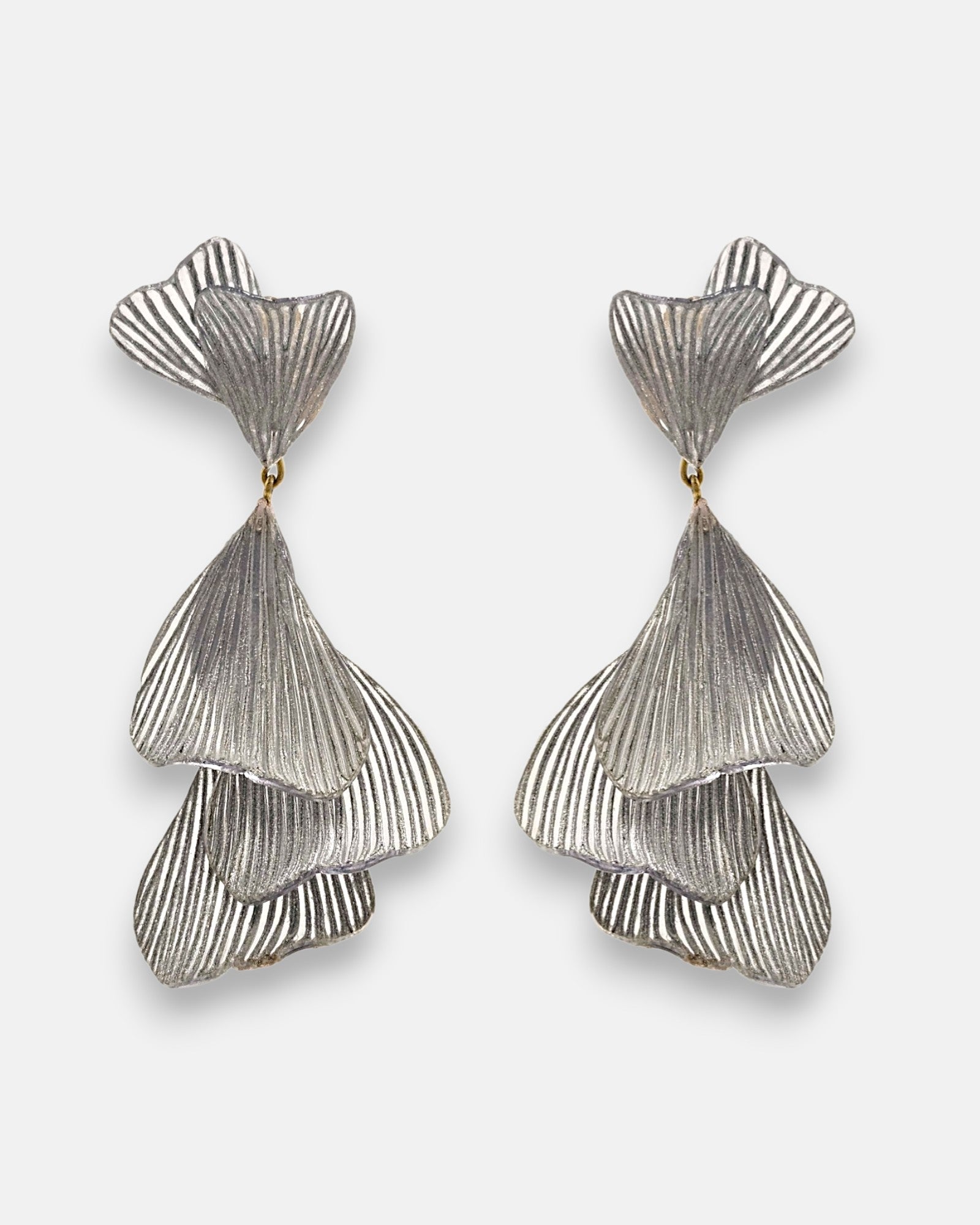 pareja de pendientes colgantes maxi de Ciléa Paris con hojas estriadas superpuestas en color plata satinada y botón superior en forma de abanico.