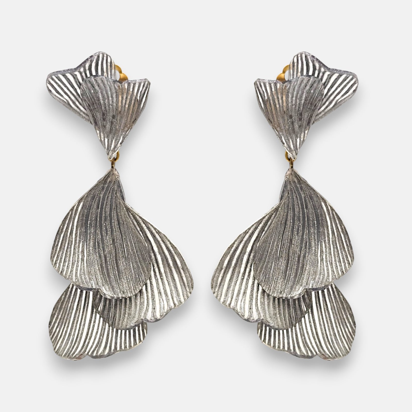 pareja de pendientes colgantes maxi de Ciléa Paris con hojas estriadas superpuestas en color plata satinada y botón superior articulado en forma de abanico.