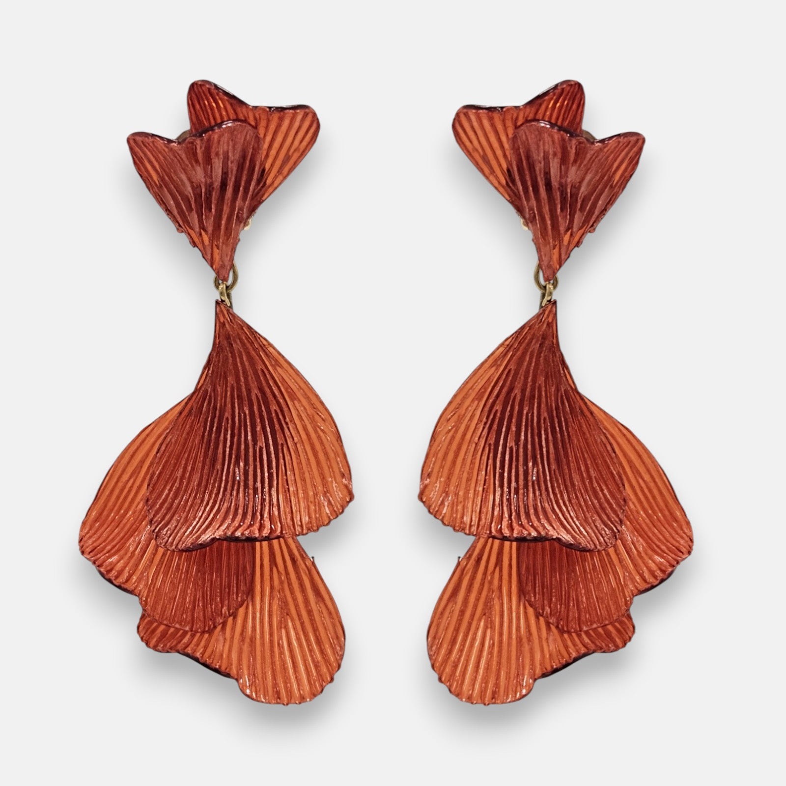 pareja de pendientes colgantes maxi con forma de hojas de ginkgo biloba de Ciléa Paris, destacando su resina texturizada en color terracota o teja brillante y su estructura de hojas superpuestas en cascada.