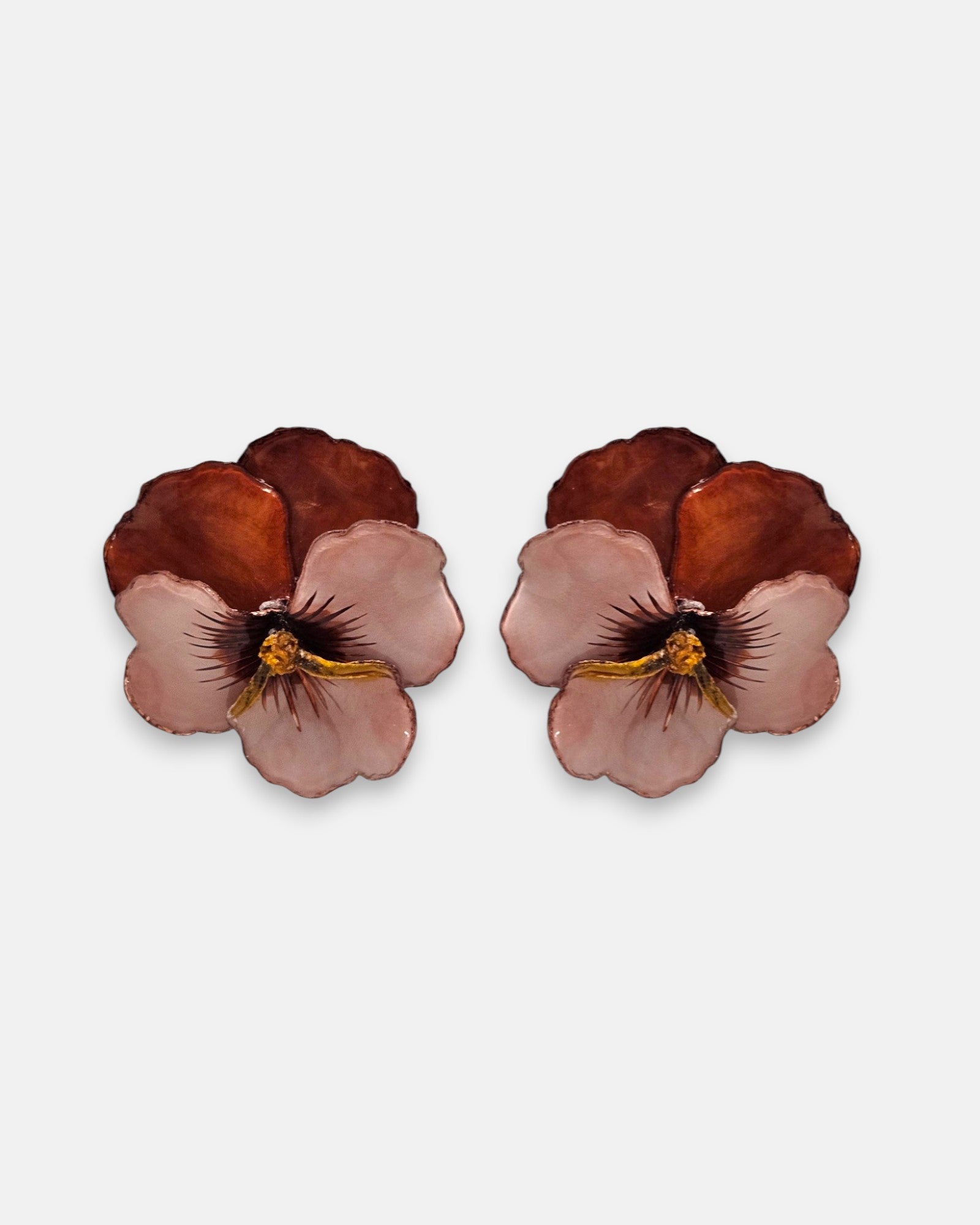 pareja de pendientes con forma de flor de pensamiento de Ciléa Paris, destacando sus pétalos superiores marrón caramelo y sus pétalos inferiores rosa claro.